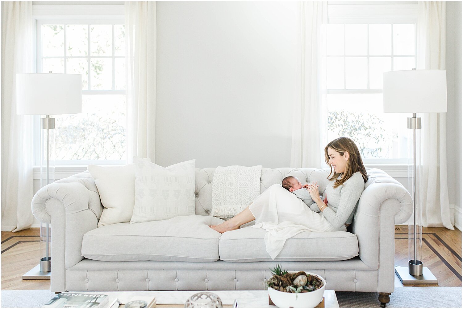 Mom and baby on couch in beautifully lit home in Westport, CT. Photos by Westport Newborn Photographer, Kristin Wood Photography.