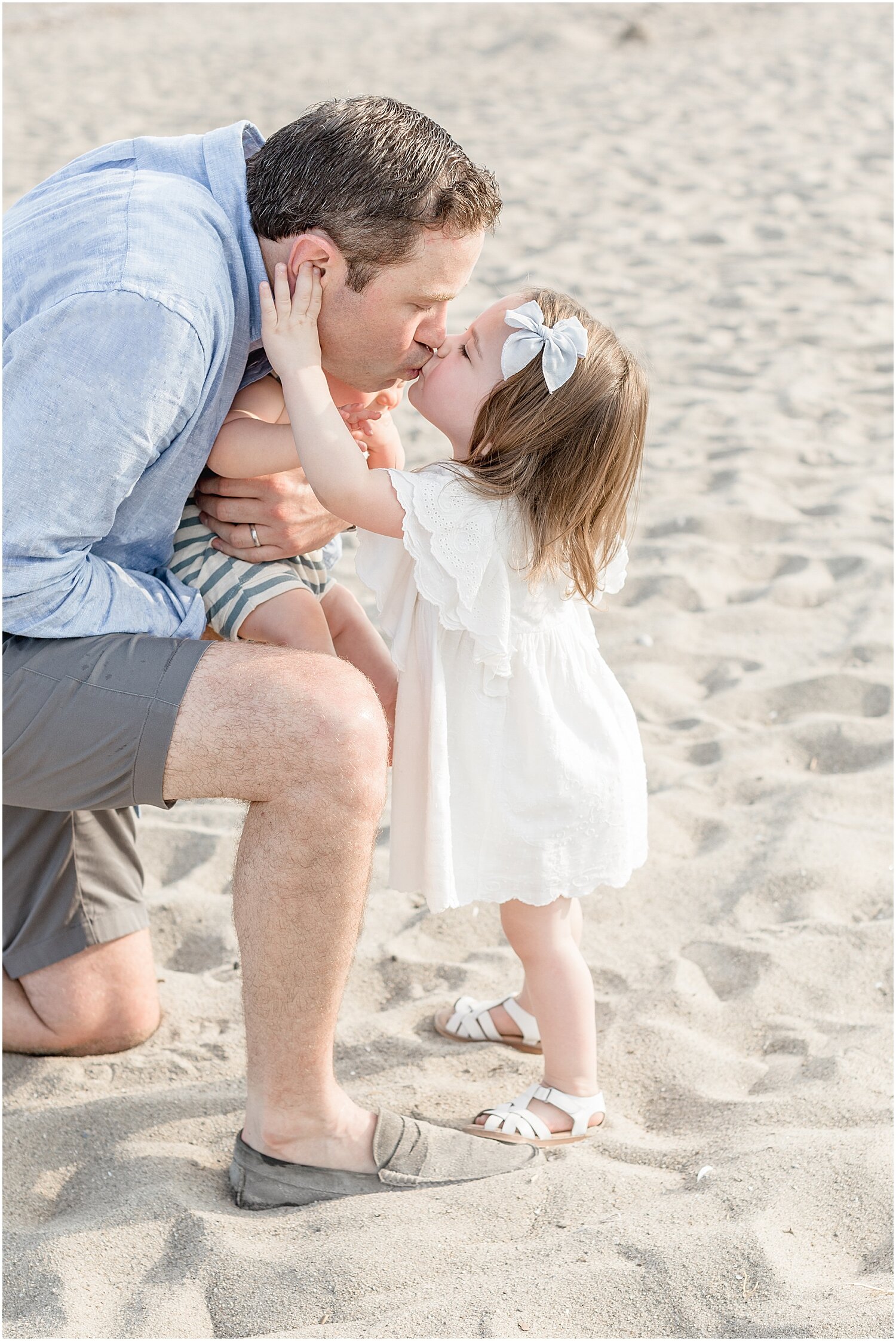 Sweet moment between Daddy and daughter on the beach in Westport, CT during family photoshoot. Photos by Westport, CT Family Photographer, Kristin Wood Photography.