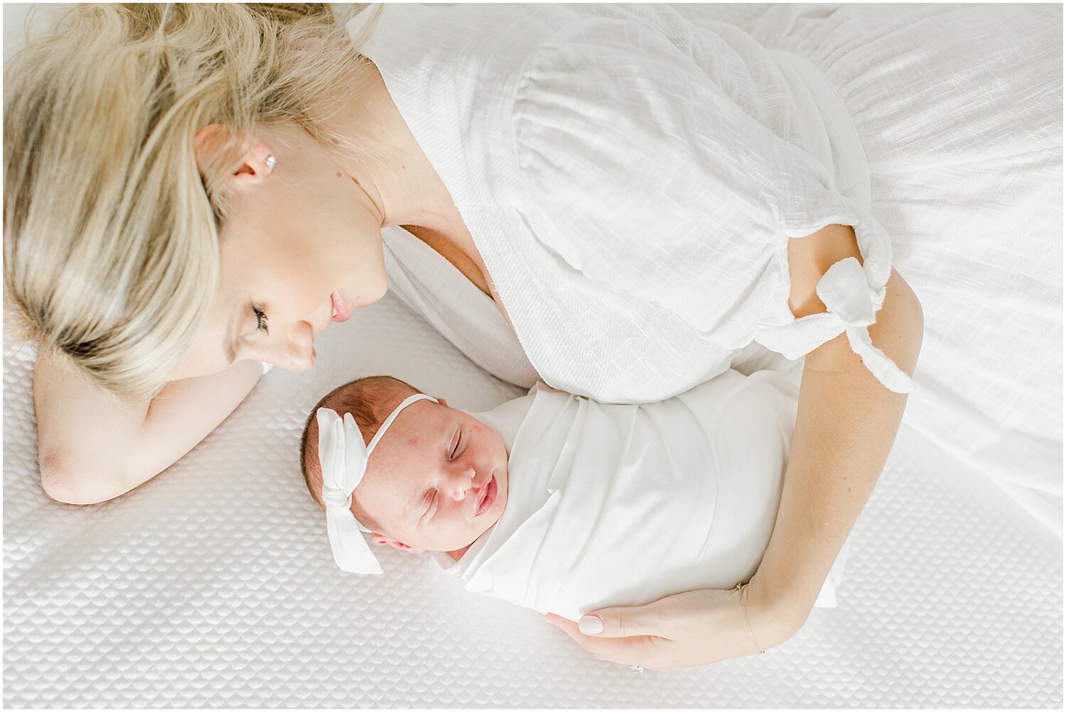 Lifestyle newborn session with Mama and baby girl on the bed. Photos by Rye, NY Newborn Photographer, Kristin Wood Photography.