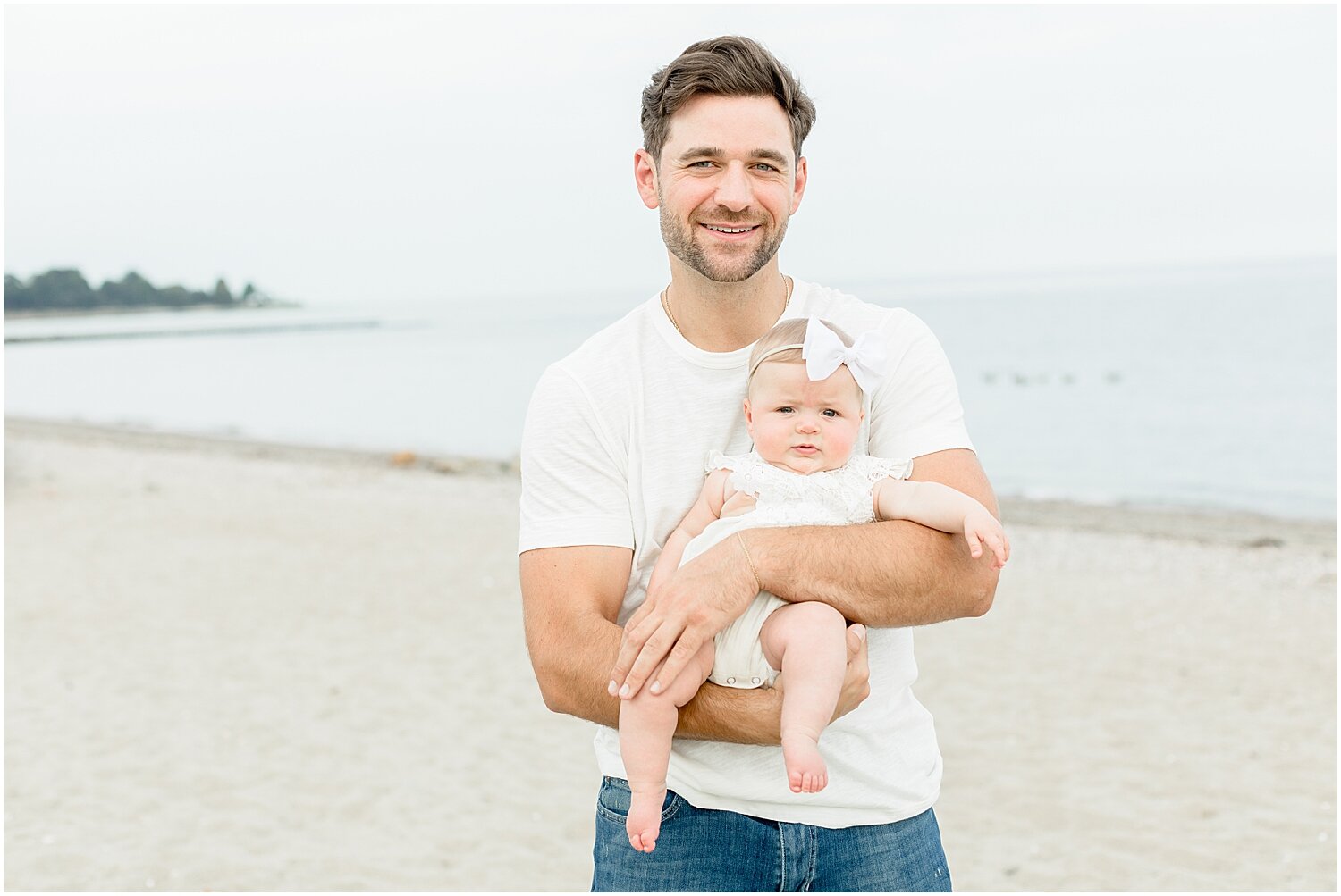 Dad with baby girl at 6 month milestone session on the beach in Westport, CT. Photos by Kristin Wood Photography.