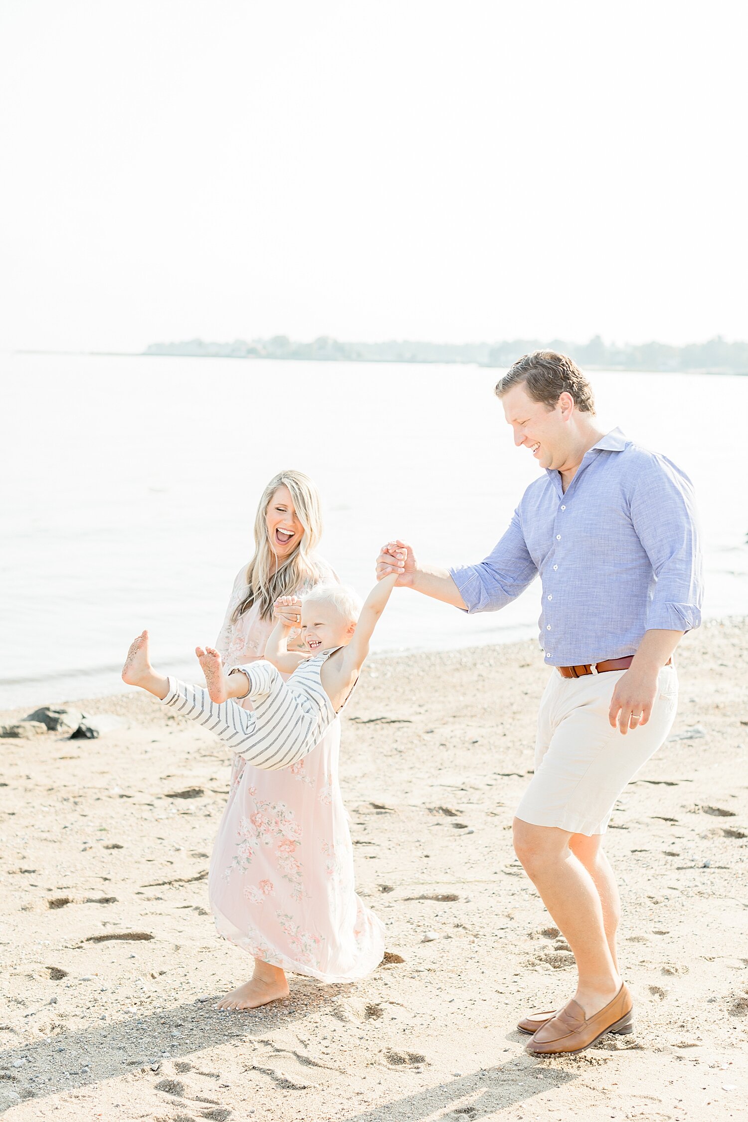 Mom and Dad swinging their son during maternity session at Weed Beach | Kristin Wood Photography