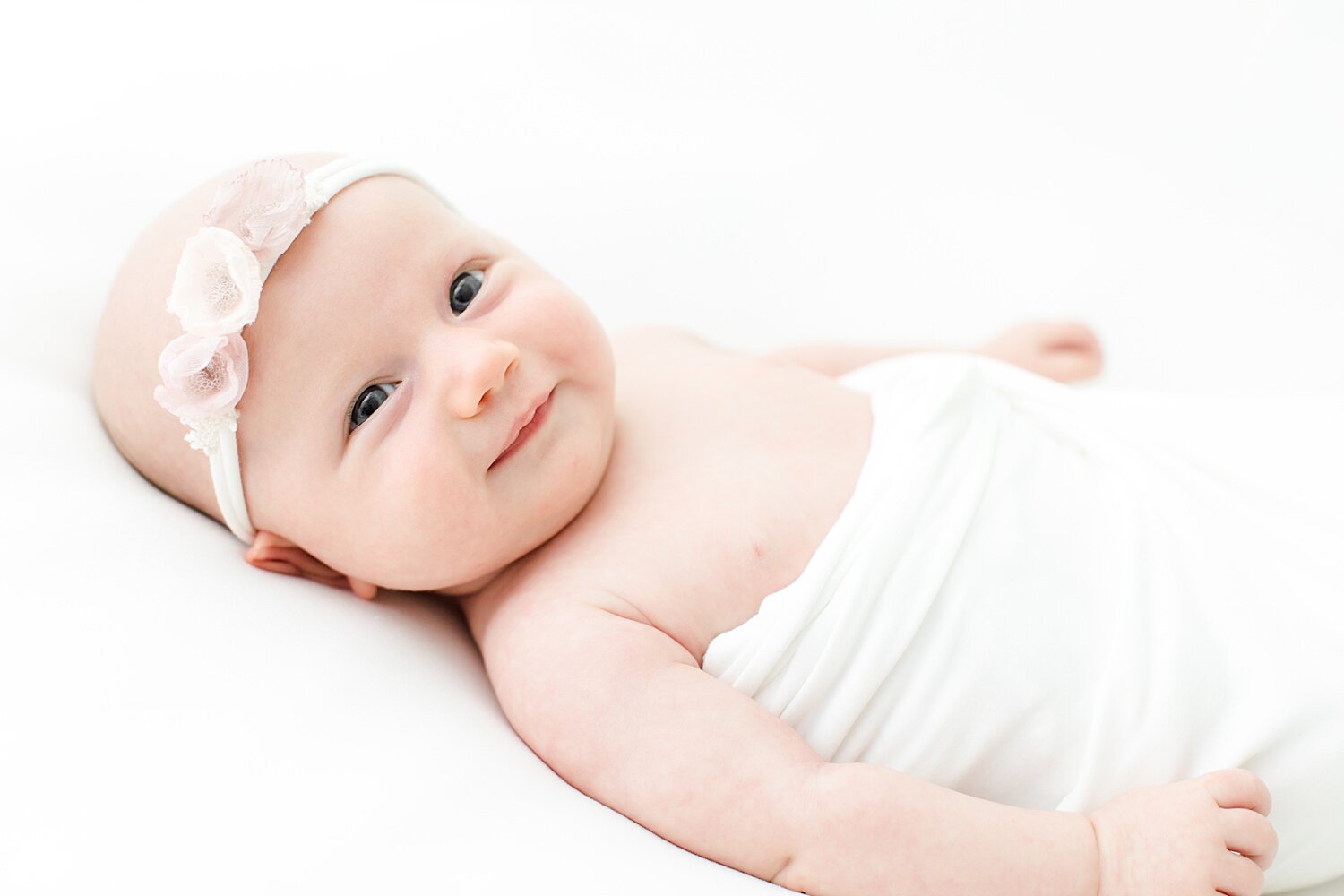 Newborn smiling during photoshoot. Photos by Kristin Wood Photography. 