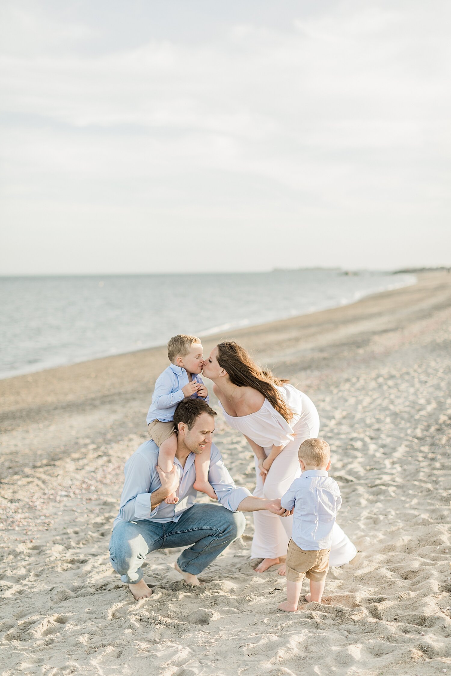 Family photo on the beach in Connecticut during maternity session with Kristin Wood Photography.