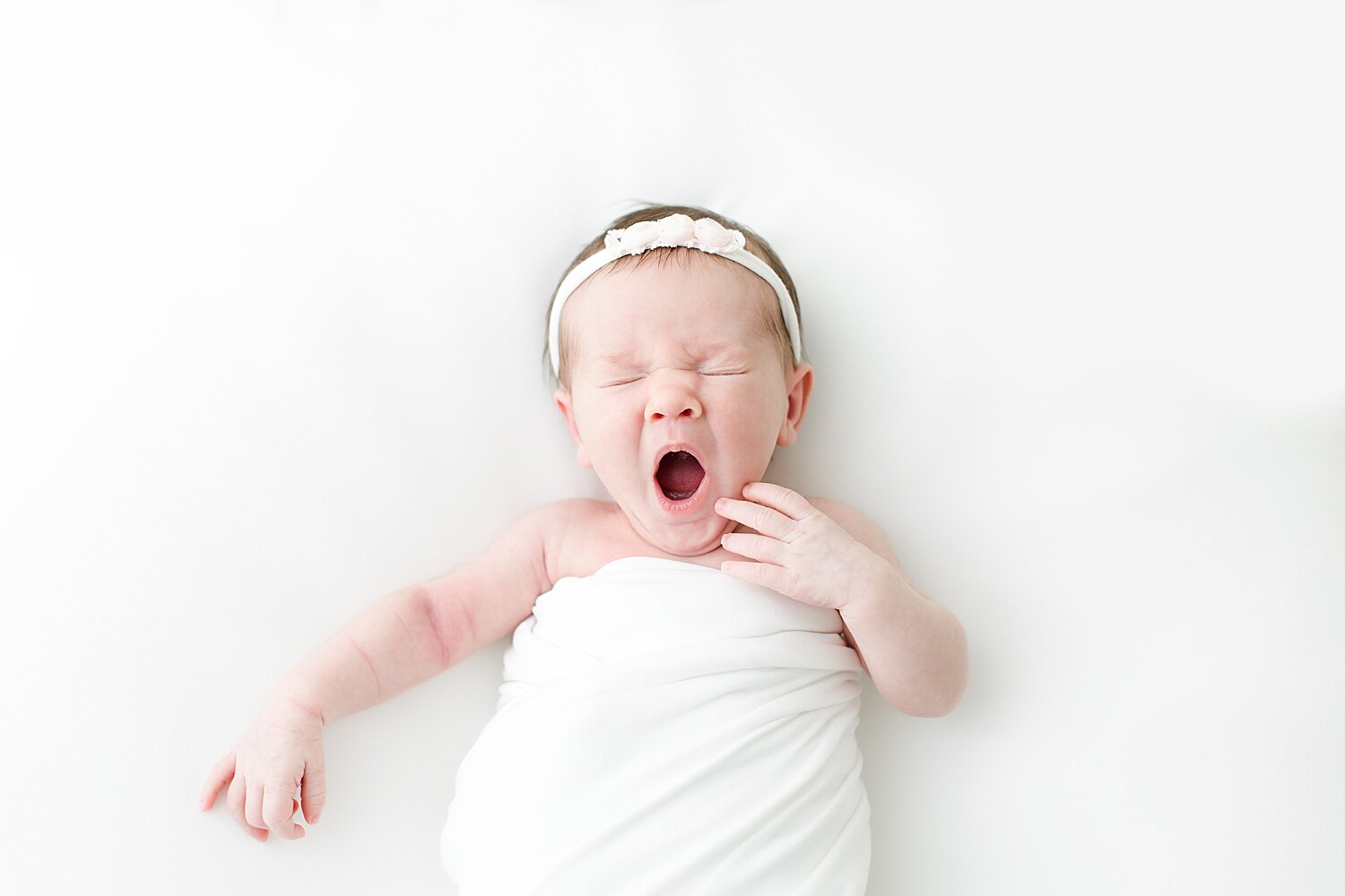Baby girl yawning during newborn session with Kristin Wood Photography. 