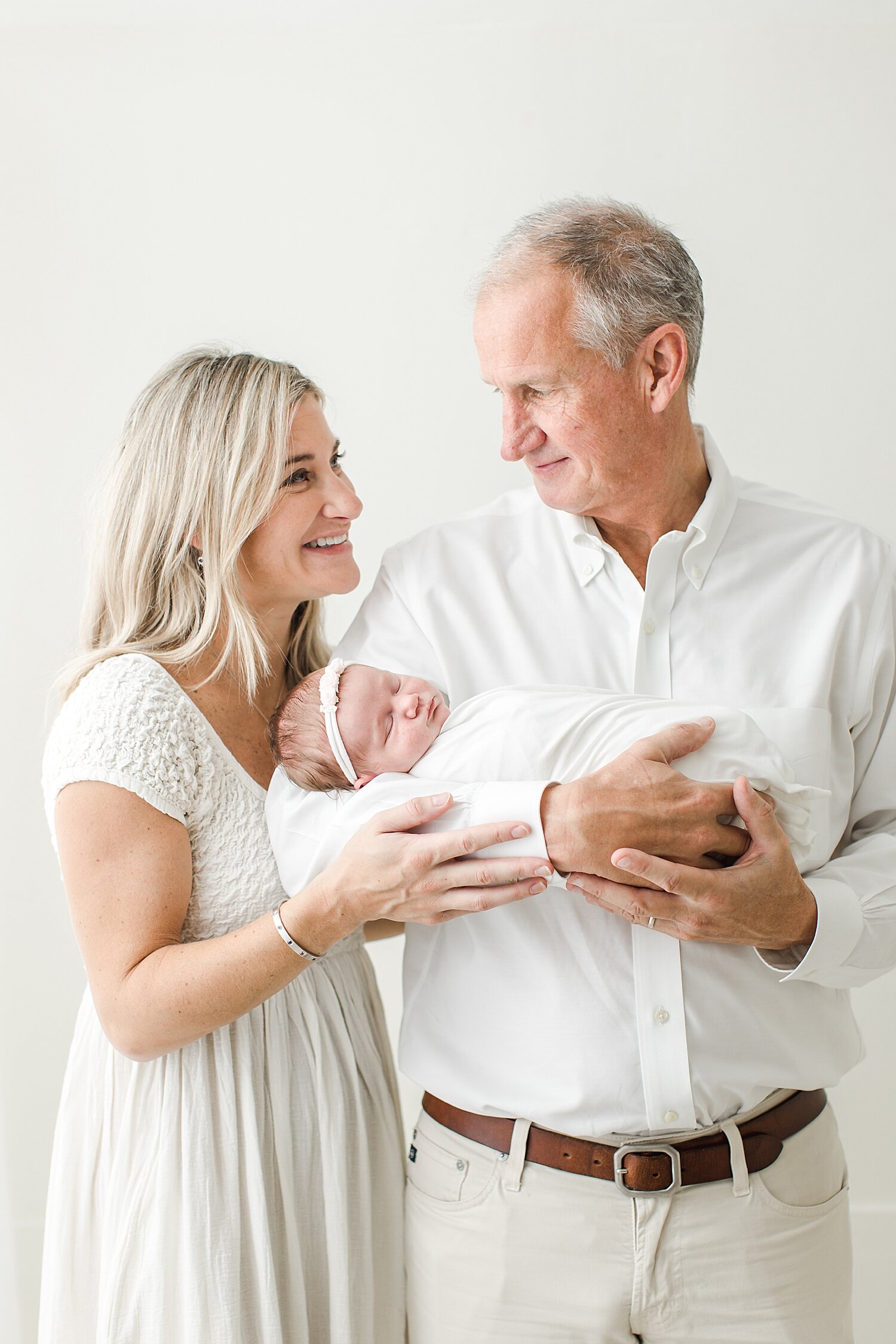 Mom and dad looking at each other during their daughters newborn session. Photos by Kristin Wood Photography. 