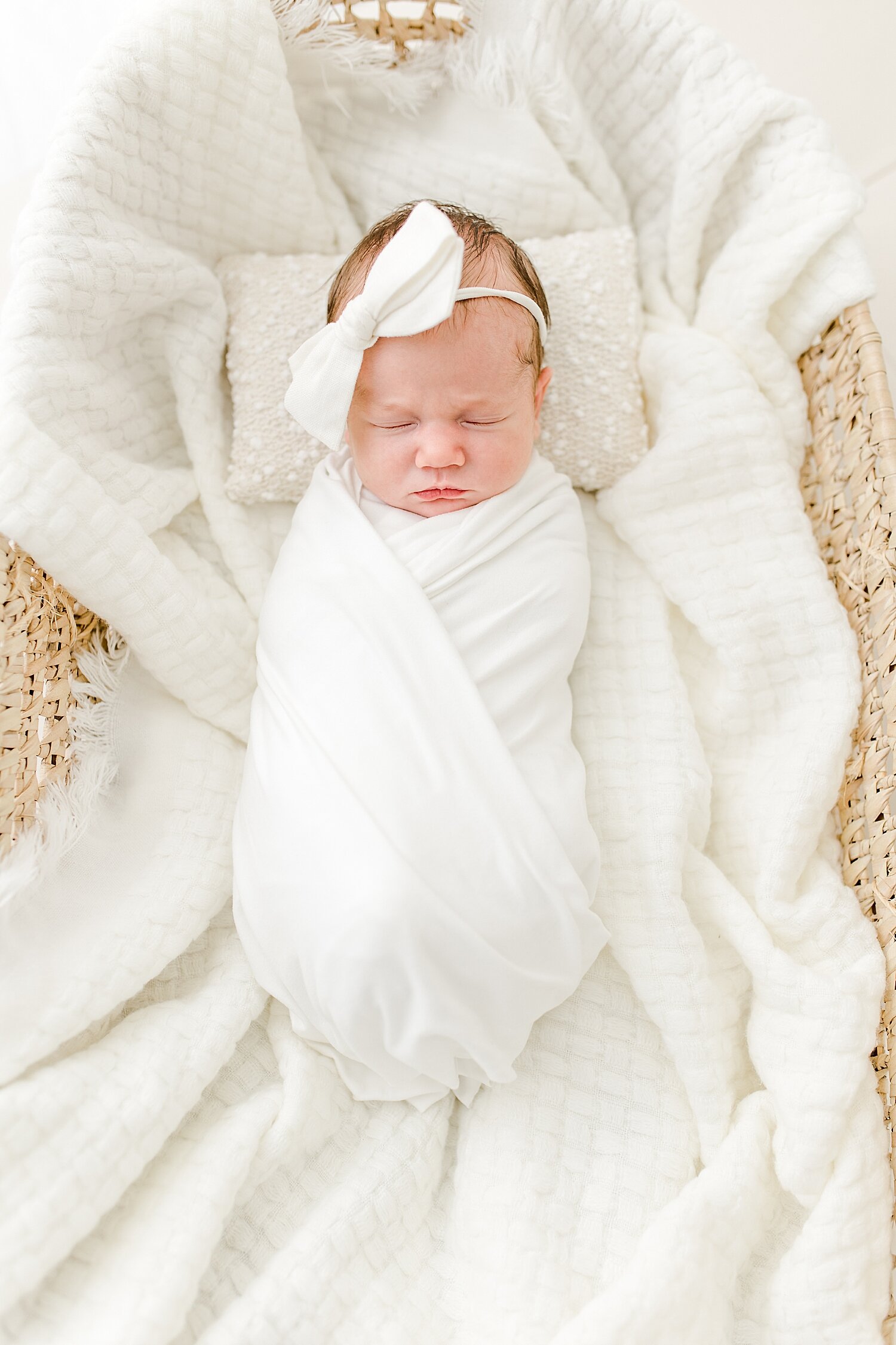 Baby girl swaddled in Moses basket for newborn session with Kristin Wood Photography. 