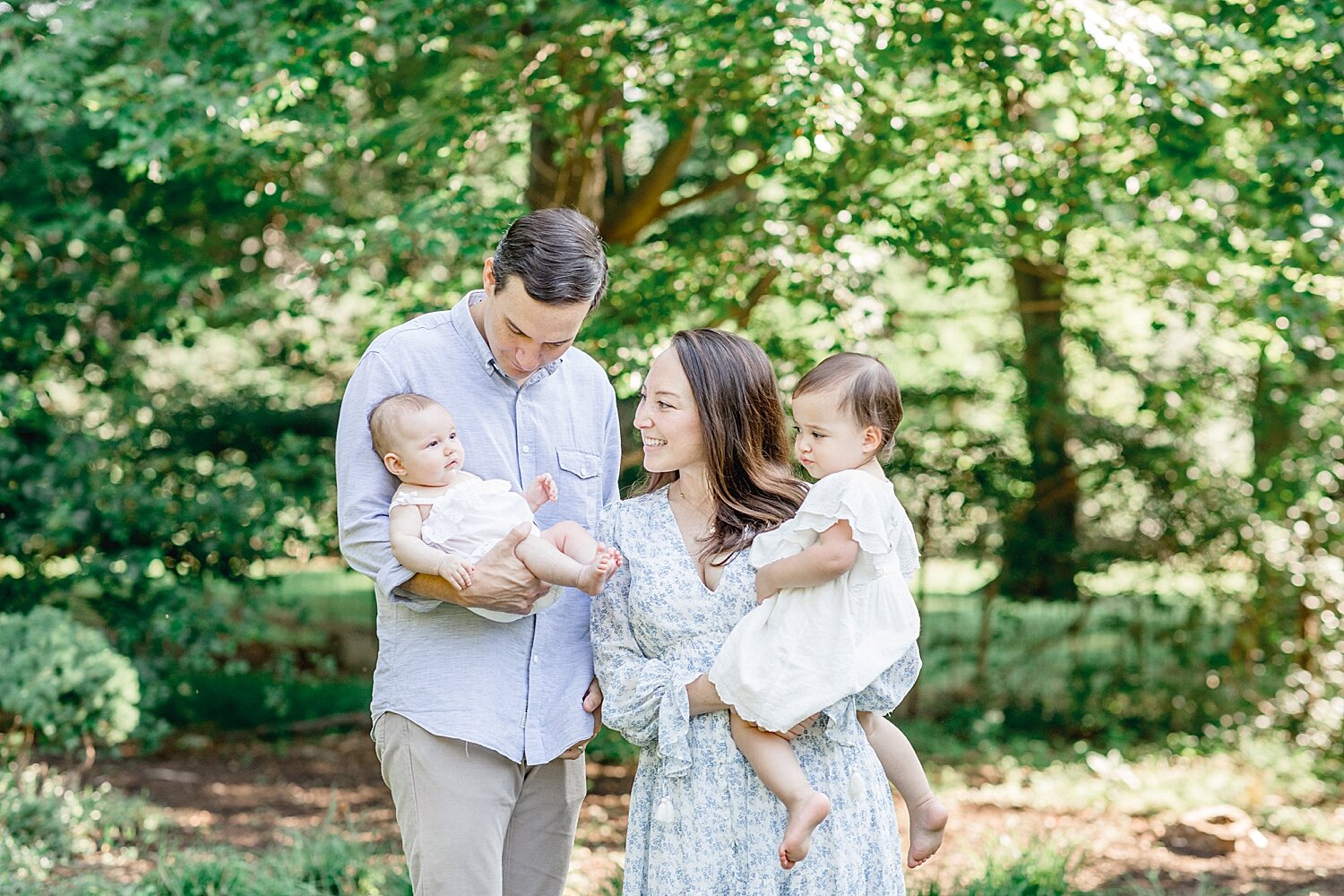 Family of four outside at a park for newborn photoshoot during pandemic. Photos by Kristin Wood Photography.