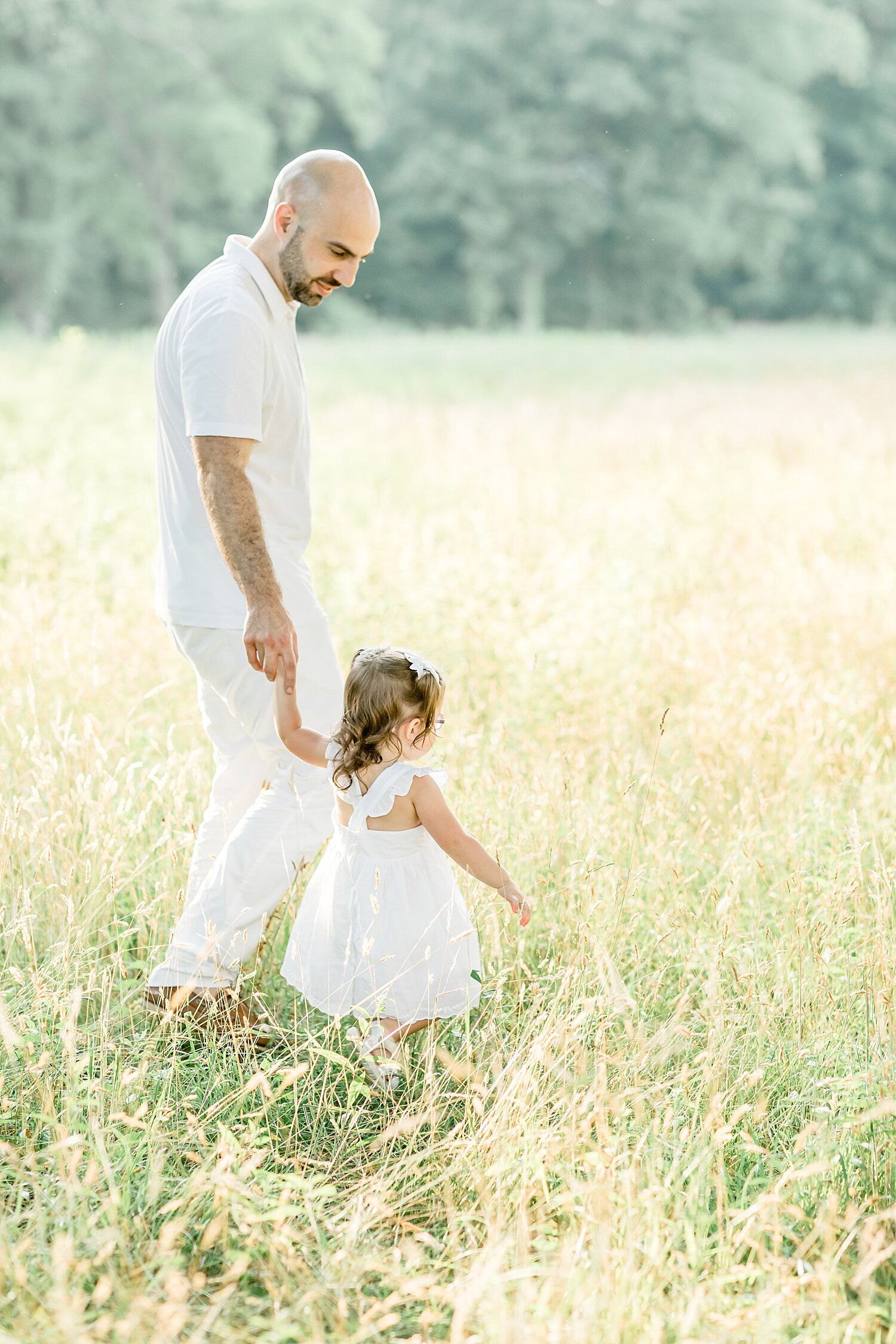 Father and daughter walking through the field at Waveny Park | Kristin Wood Photography
