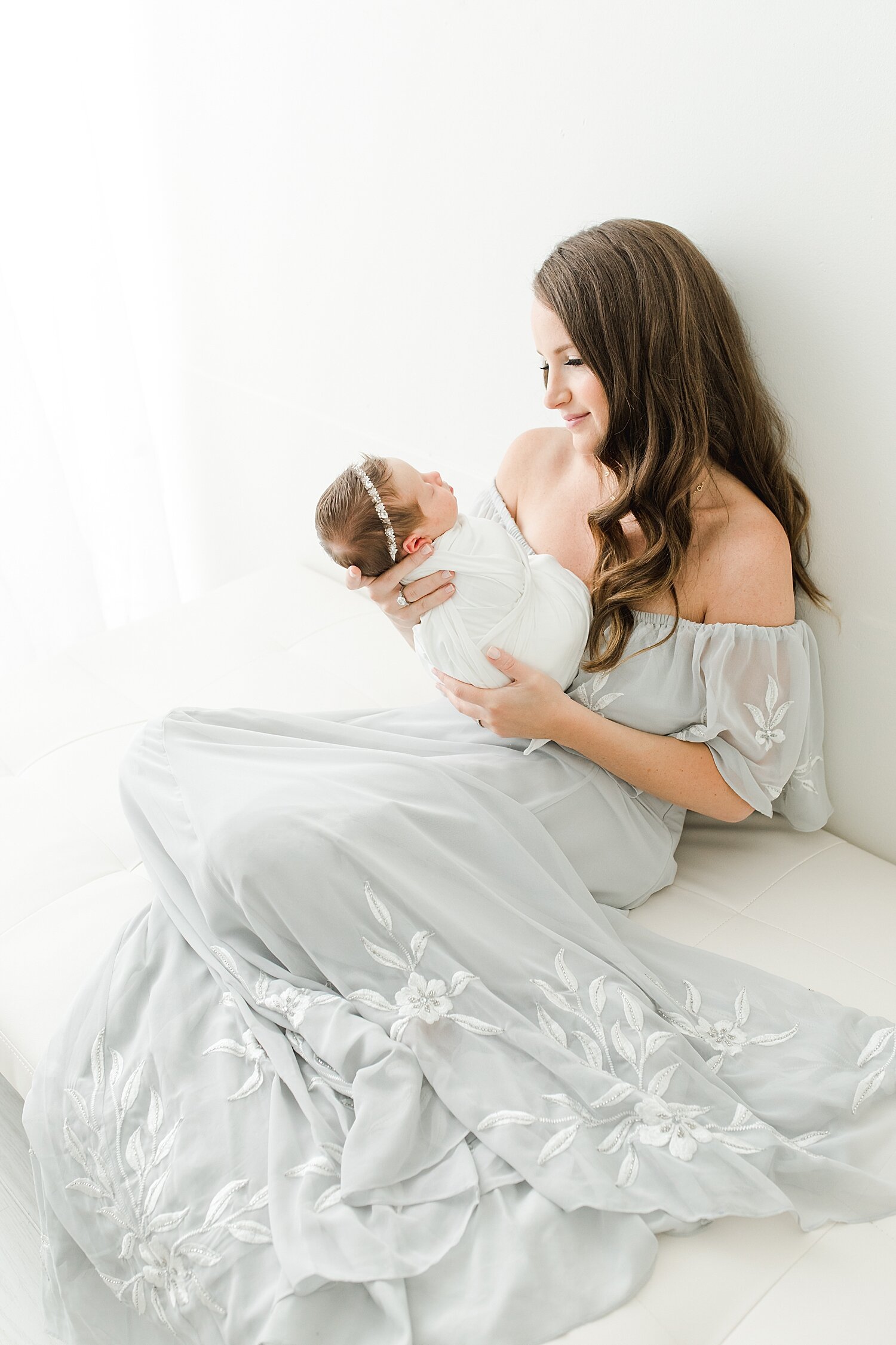 Mom holding baby girl during newborn session with Kristin Wood Photography.