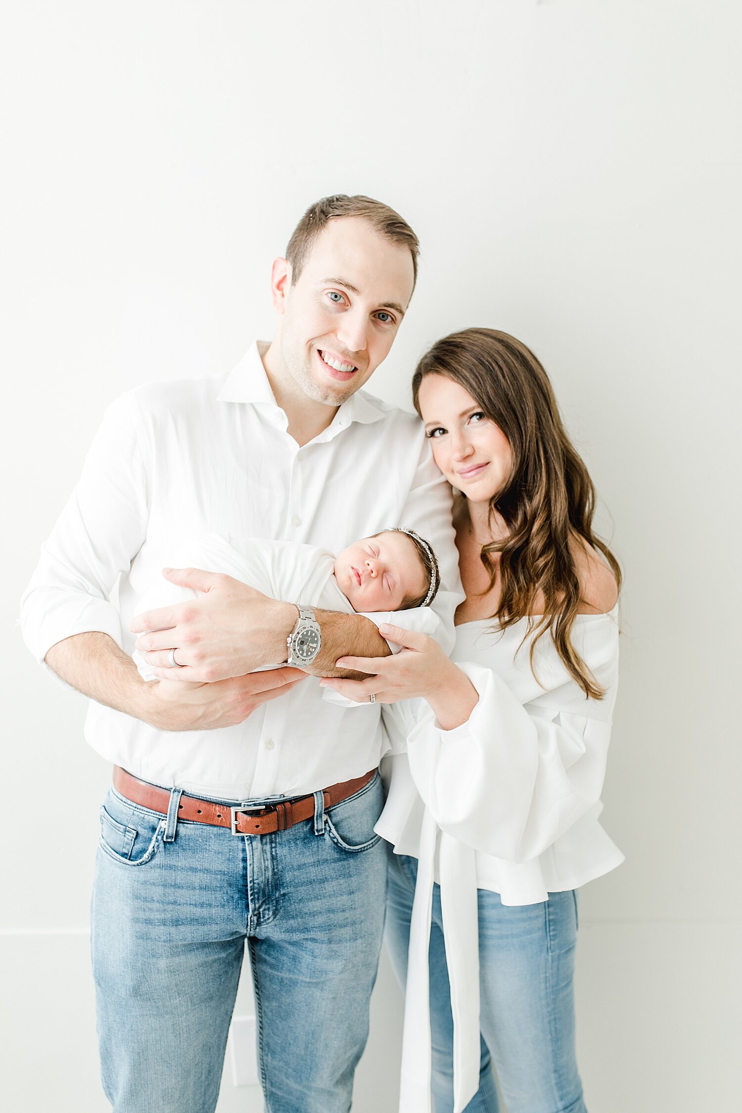 Mom and Dad holding their baby girl. Photos by Kristin Wood Photography.