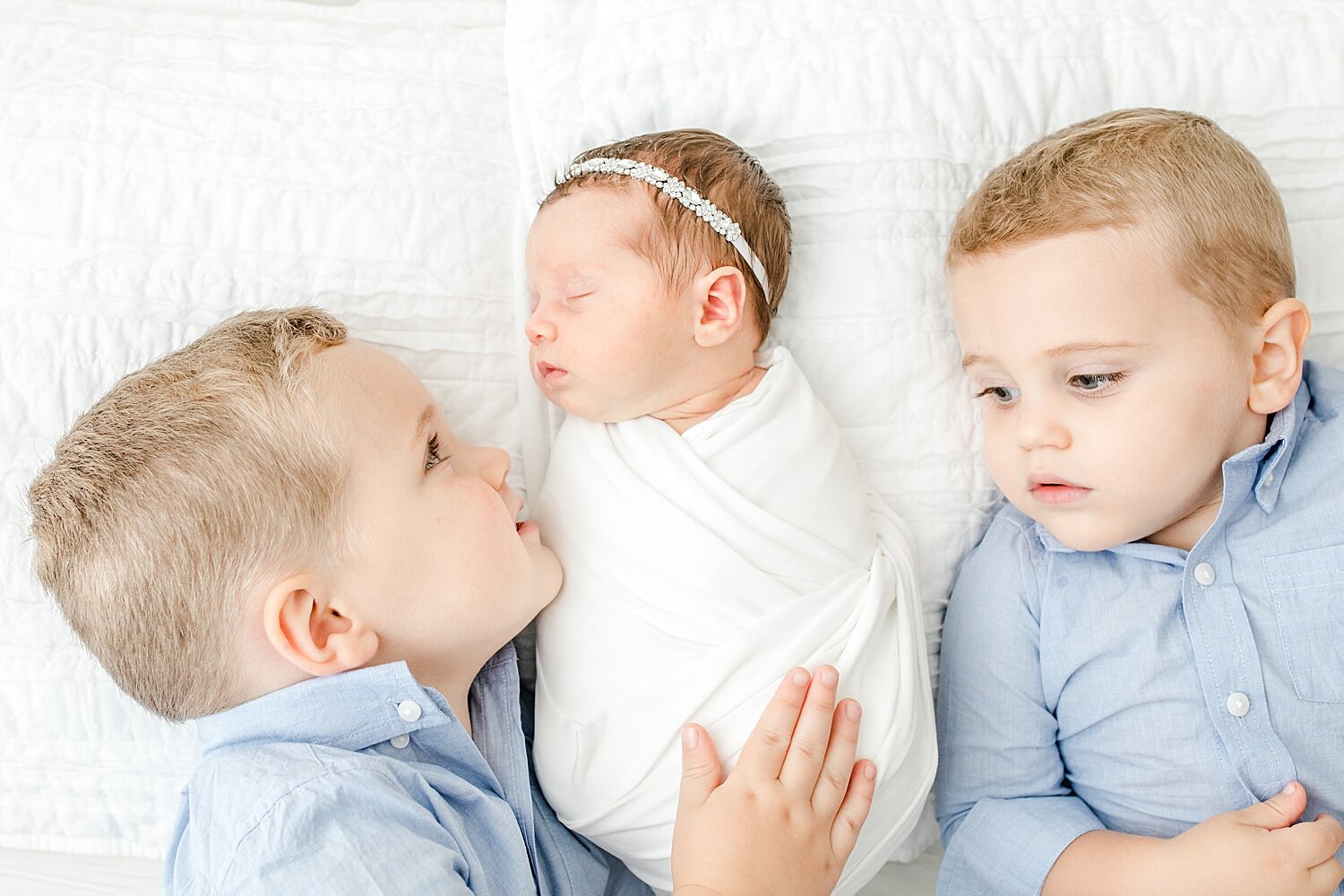 Two big brothers with their baby sister for her newborn photoshoot. Photos by Kristin Wood Photography.
