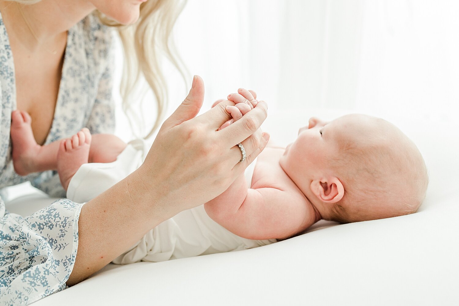 Mom holding baby's tiny little fingers. Photos by Kristin Wood Photography.