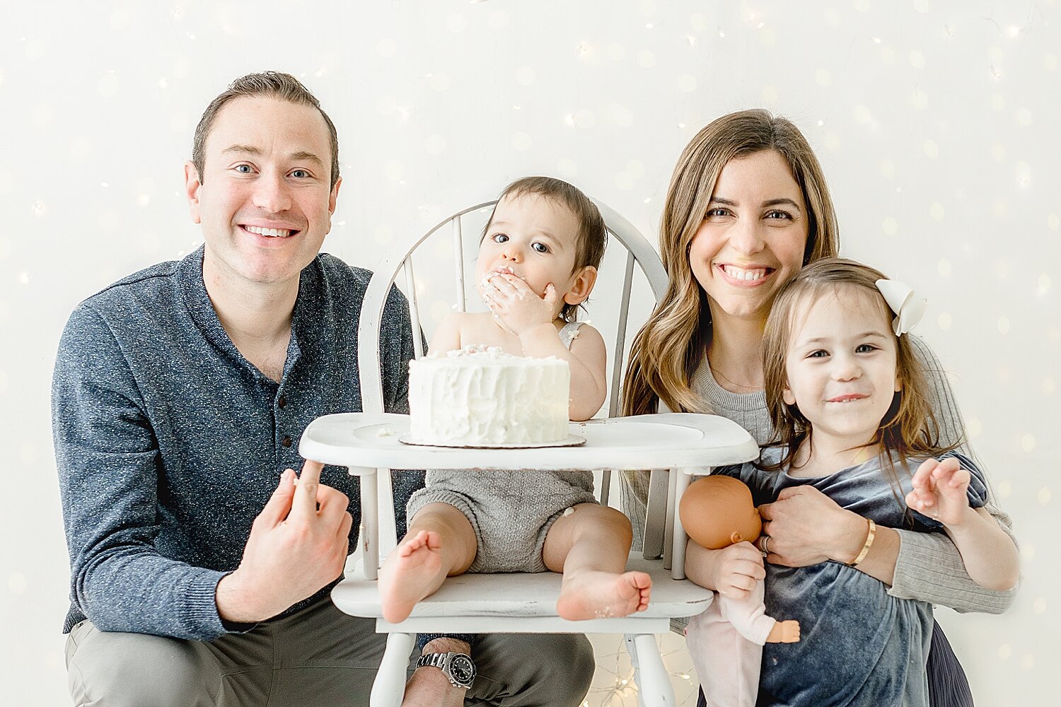 Photo of one year old boy and his family during his cake smash. Photos by Kristin Wood Photography. 