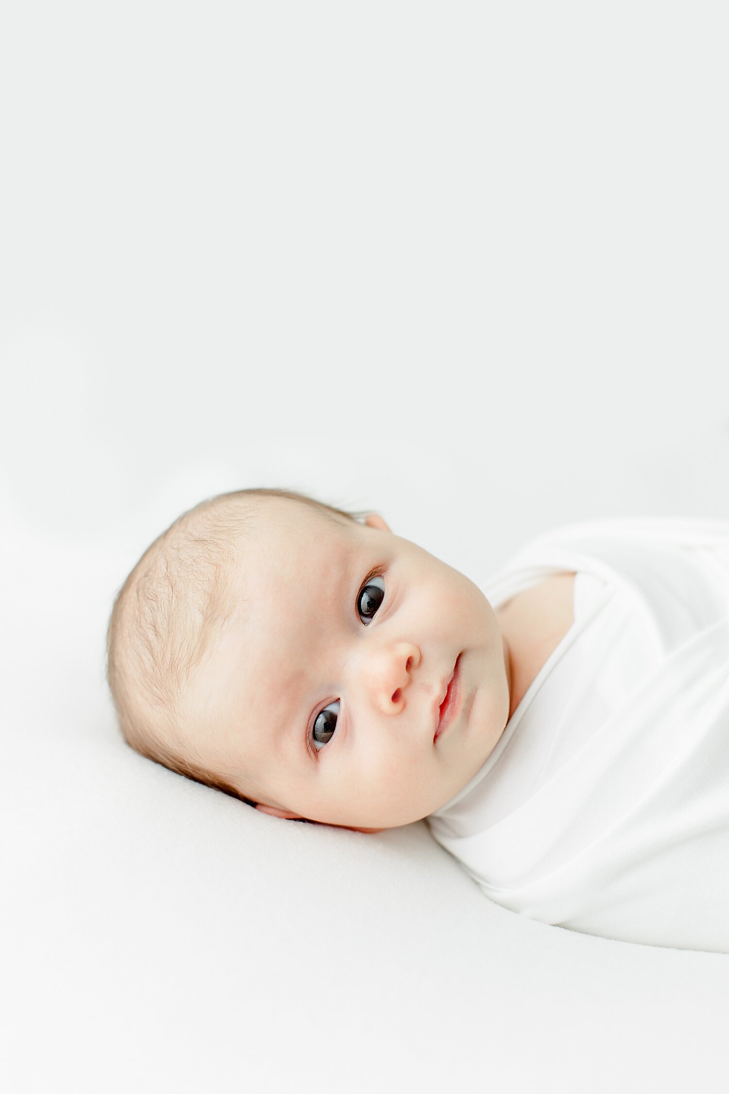 Baby boy swaddled and wide awake for his newborn photos with Kristin Wood Photography.