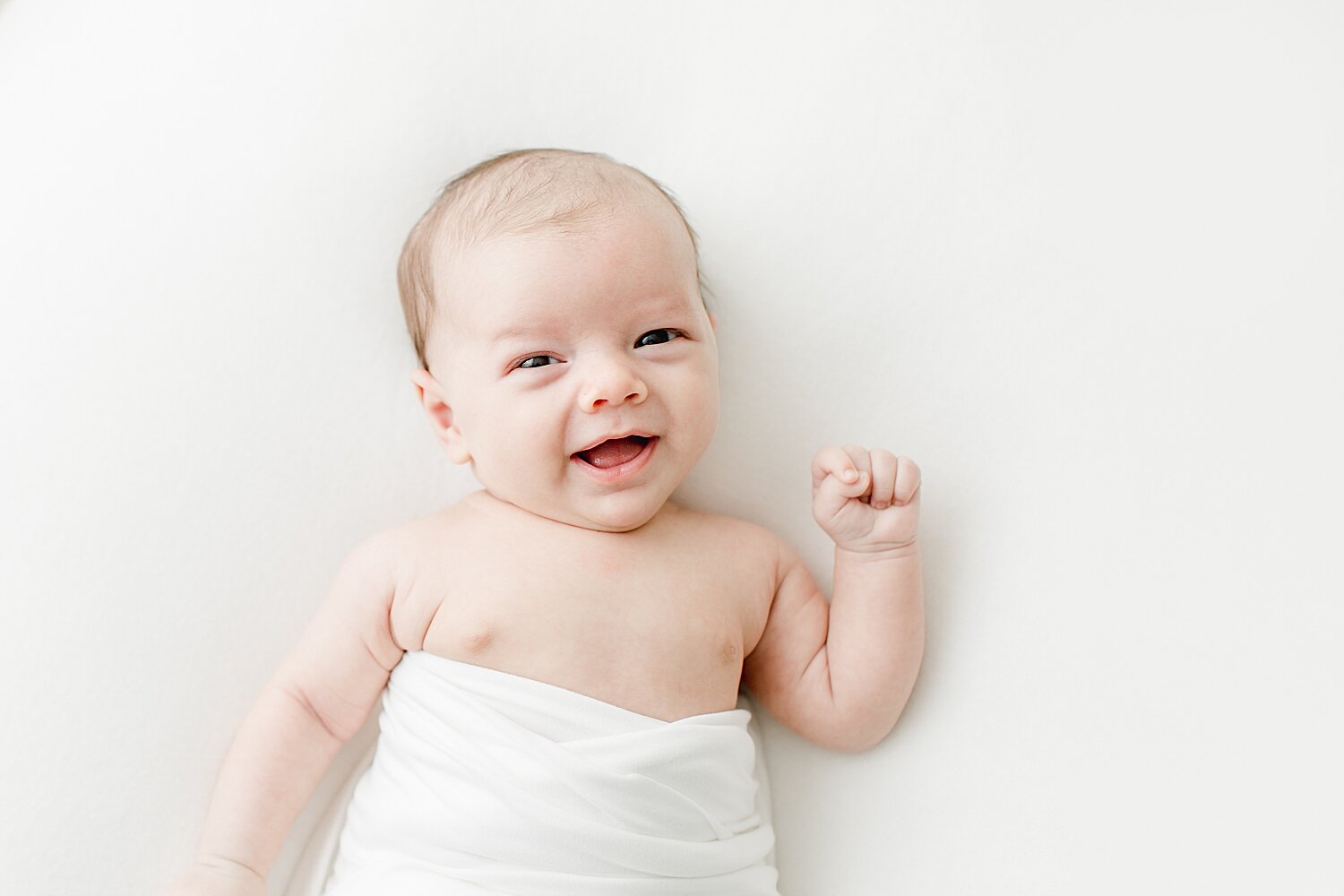 Baby boy awake and smiling for newborn session. Photos by Kristin Wood Photography.