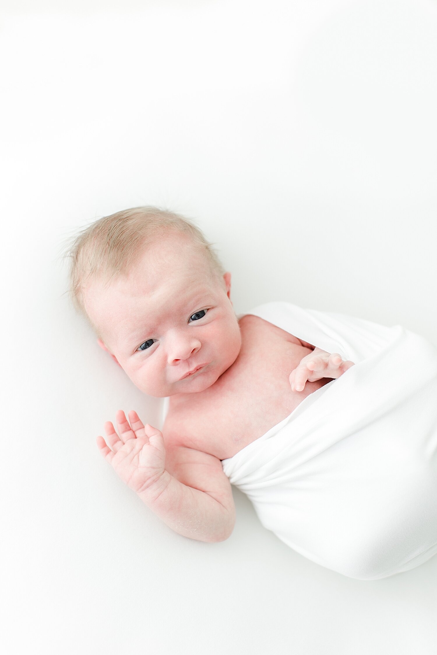 Baby boy swaddled on blanket for newborn photos with Kristin Wood Photography.
