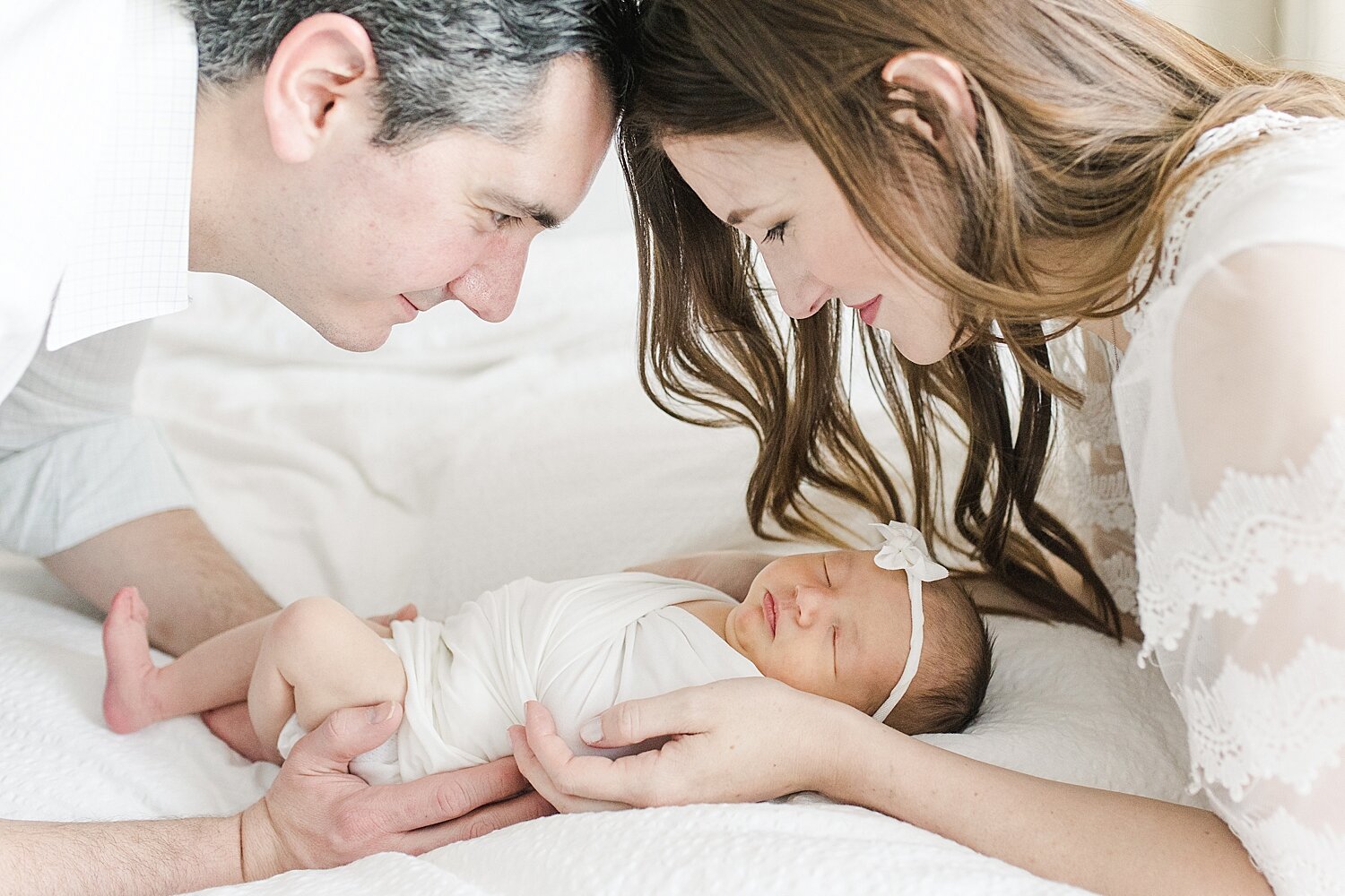 First-time parents looking over their baby girl during newborn session with Kristin Wood Photography.