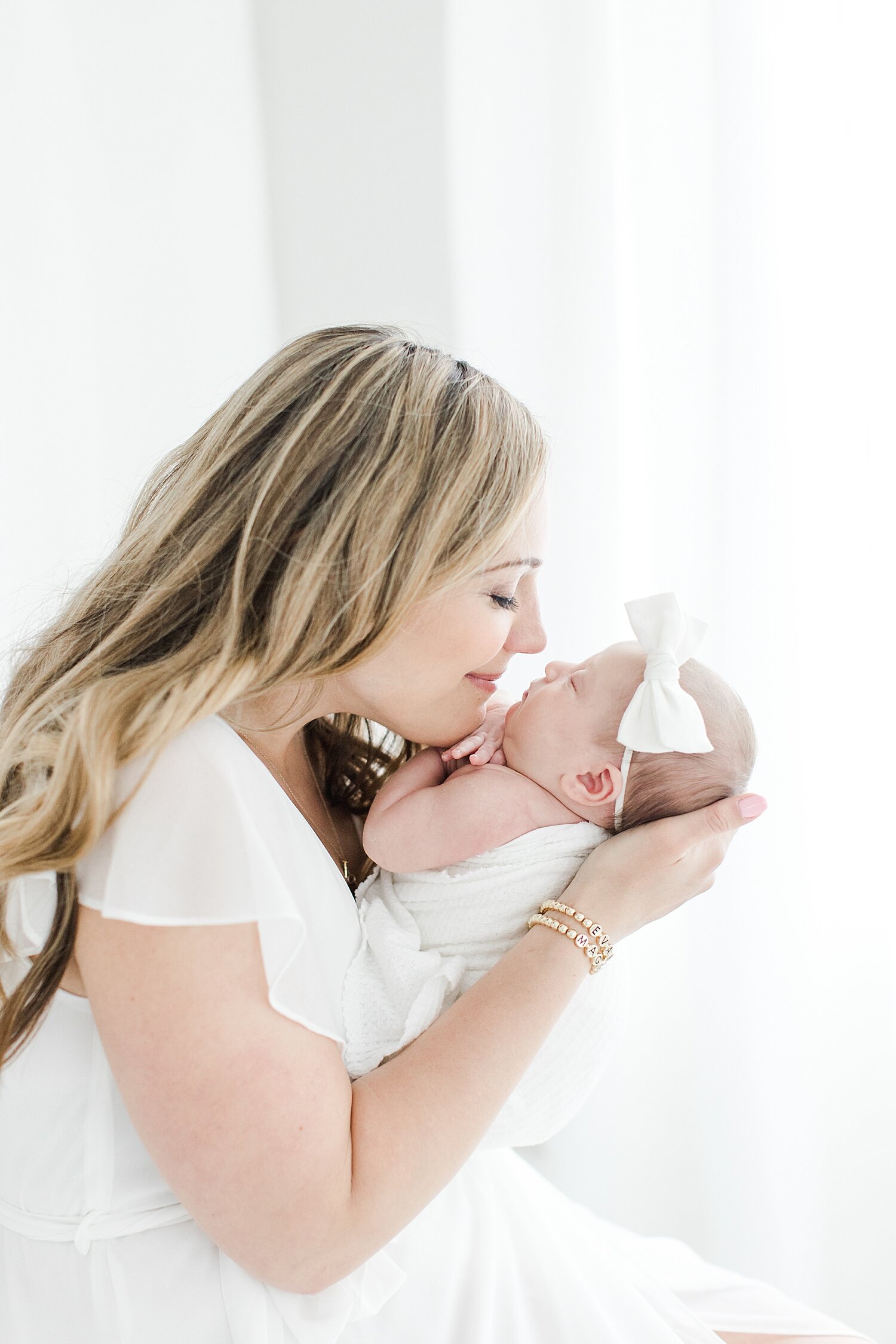 Mom kissing her baby girl during newborn session with Westport newborn photographer, Kristin Wood Photography.