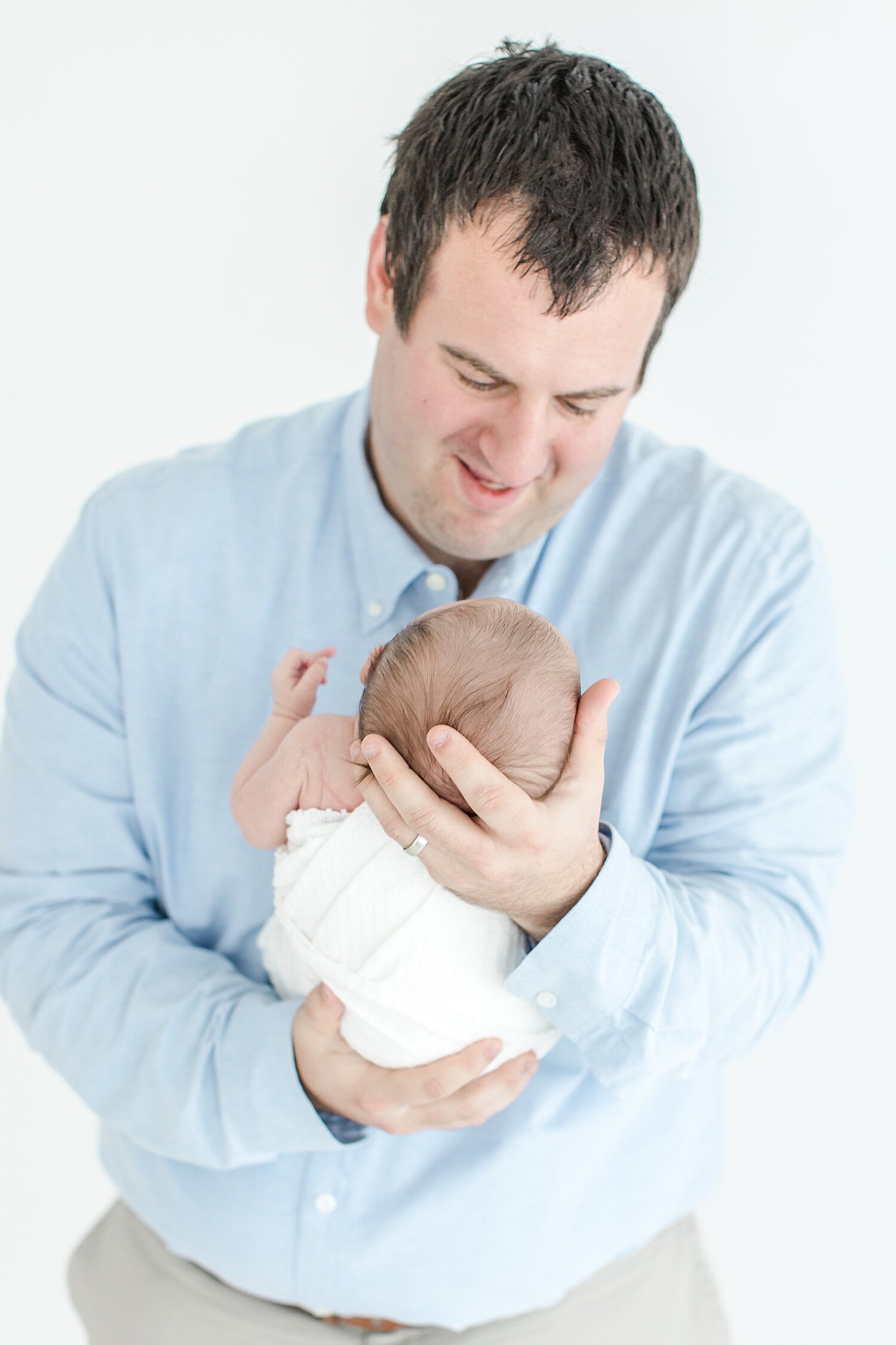 Dad holding his daughter for newborn photos with Kristin Wood Photography.