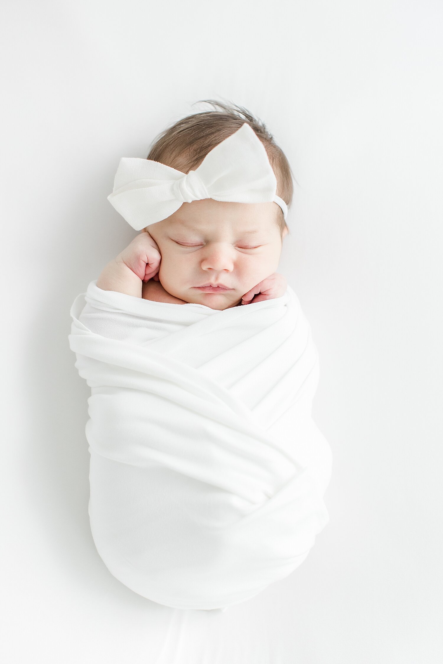 Baby girl sleeping and swaddled for newborn photos with Kristin Wood Photography.