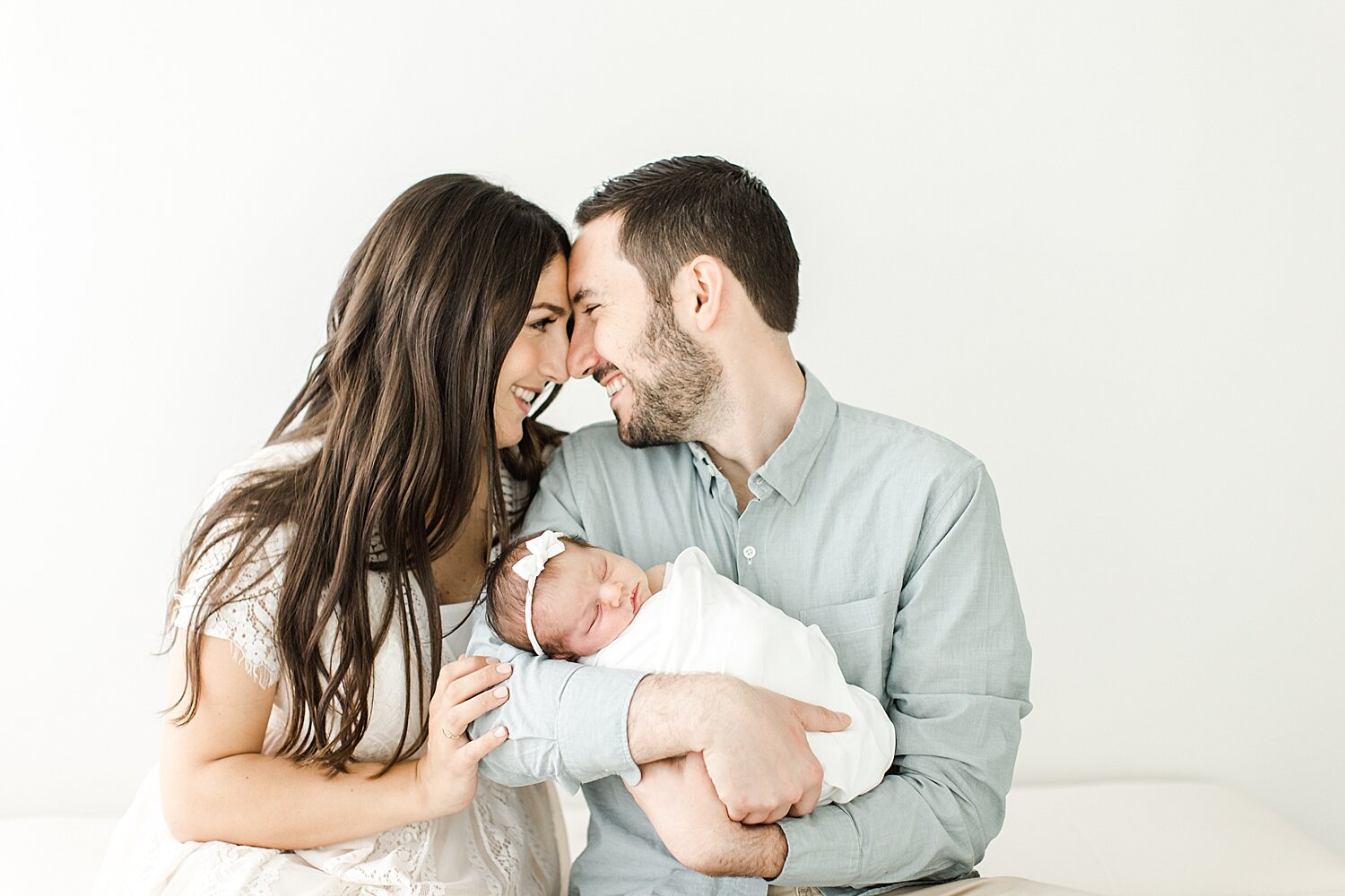 Mom and Dad looking at each other holding their daughter | Kristin Wood Photography