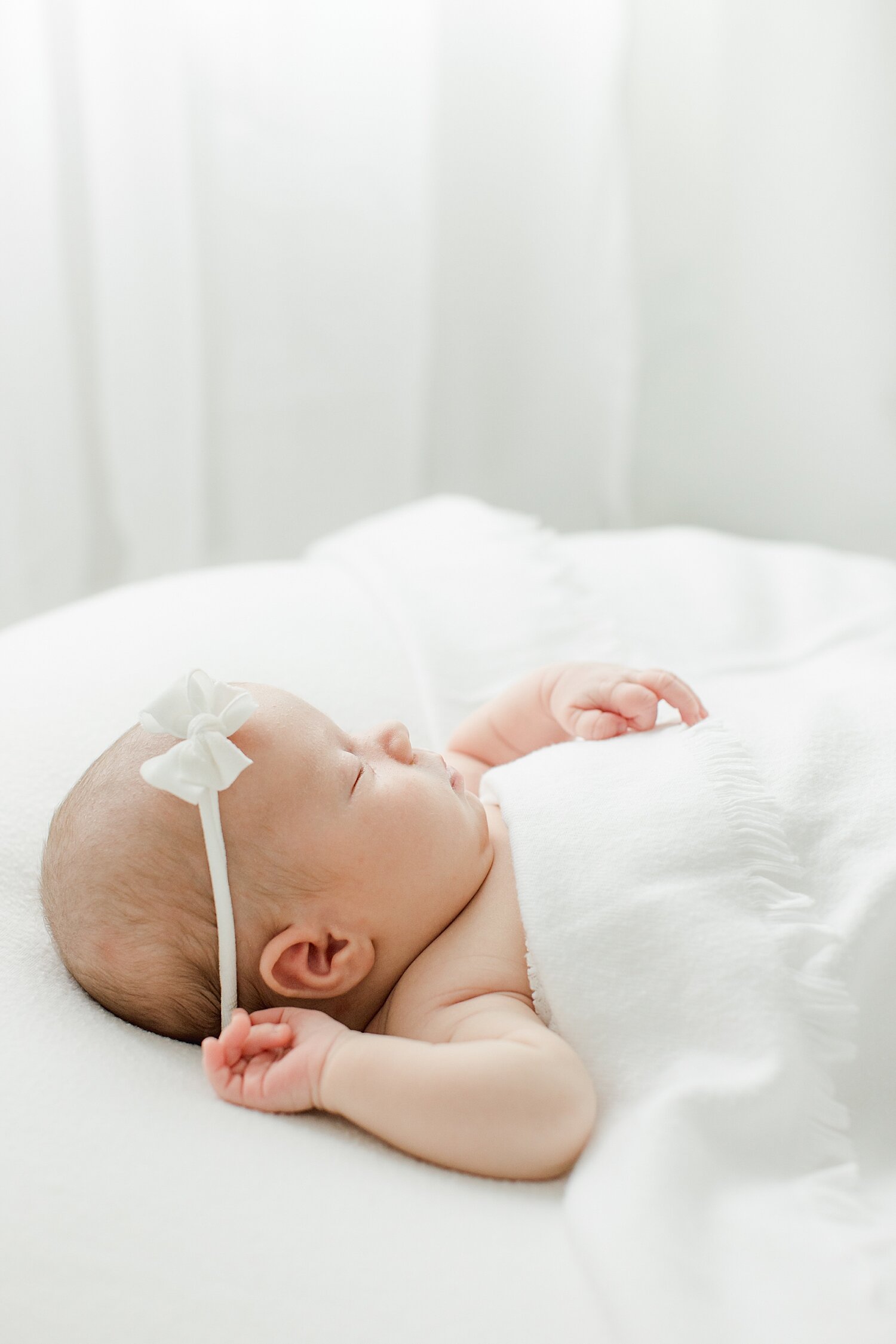 Baby girl sleeping and swaddled in white for newborn session with Kristin Wood Photography in Westport, CT. 