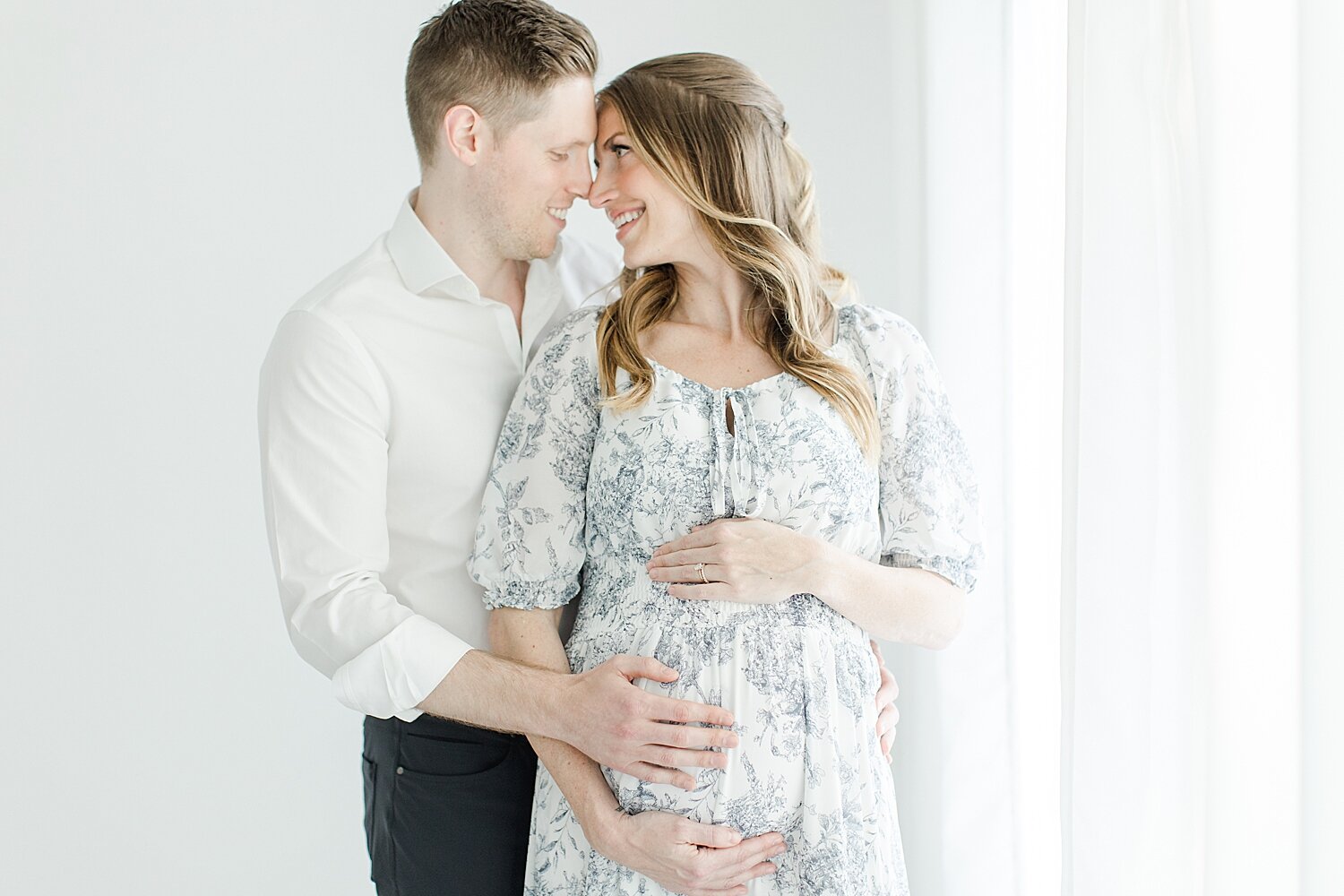 Expecting parents looking at each other during maternity photoshoot with Kristin Wood Photography.
