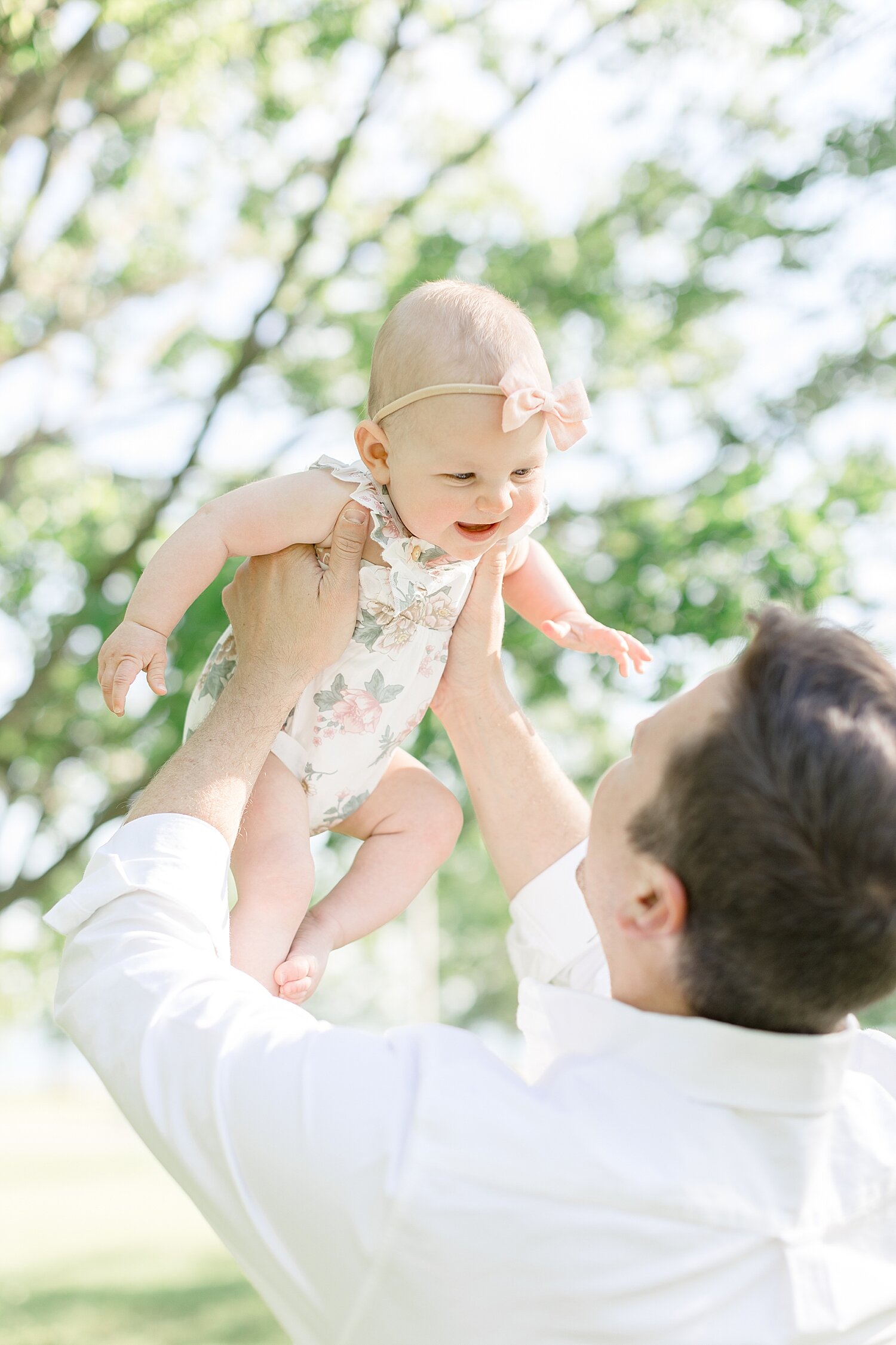 Dad holding up six month old baby girl | Kristin Wood Photography