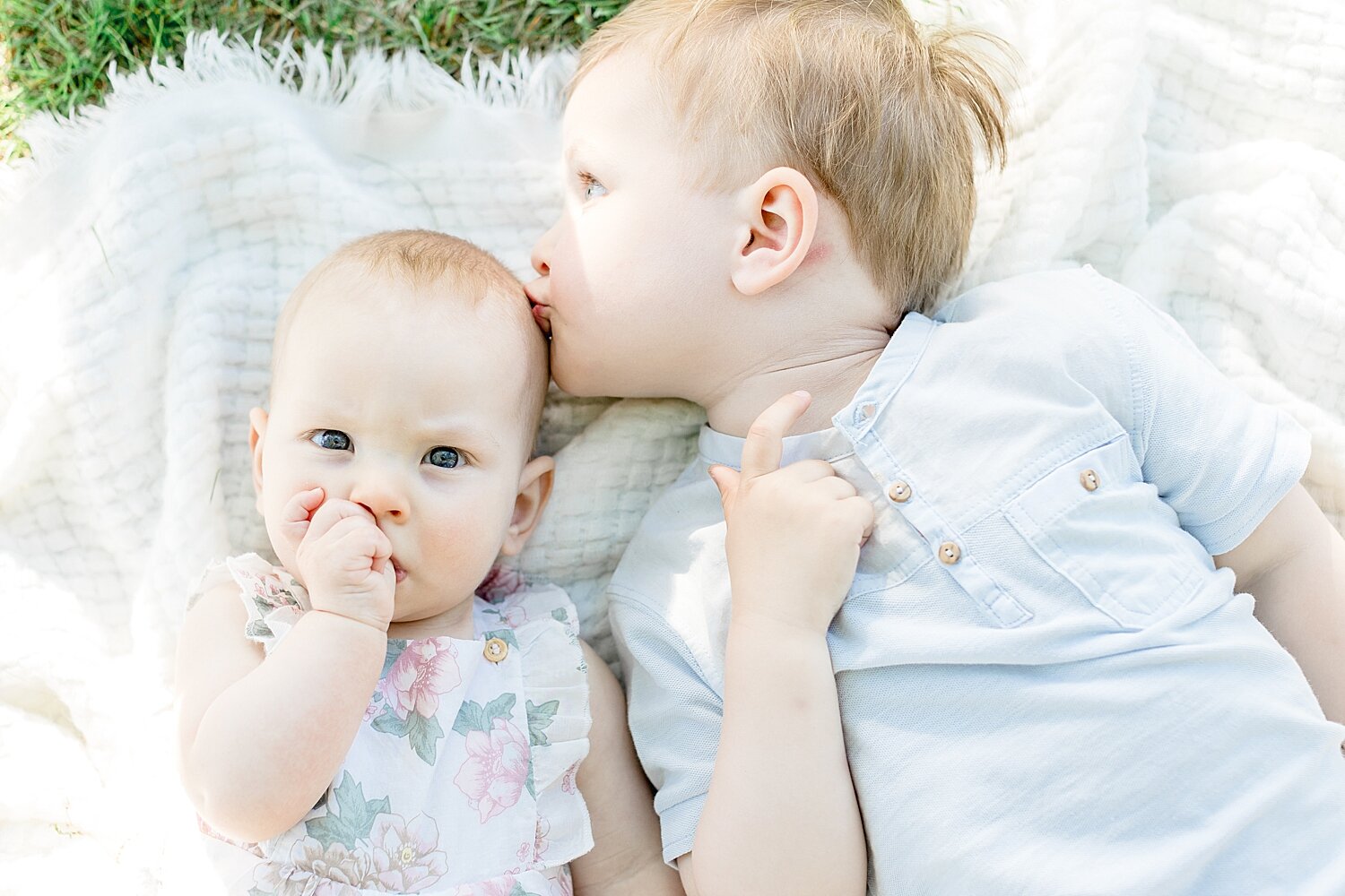 Big brother giving his baby sister a kiss on the forehead | Kristin Wood Photography