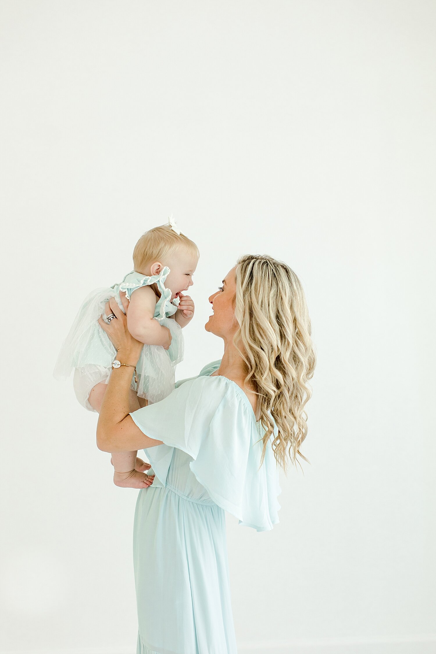 Mom holding up her baby girl for mommy and me session. Photos by Kristin Wood Phtoography.