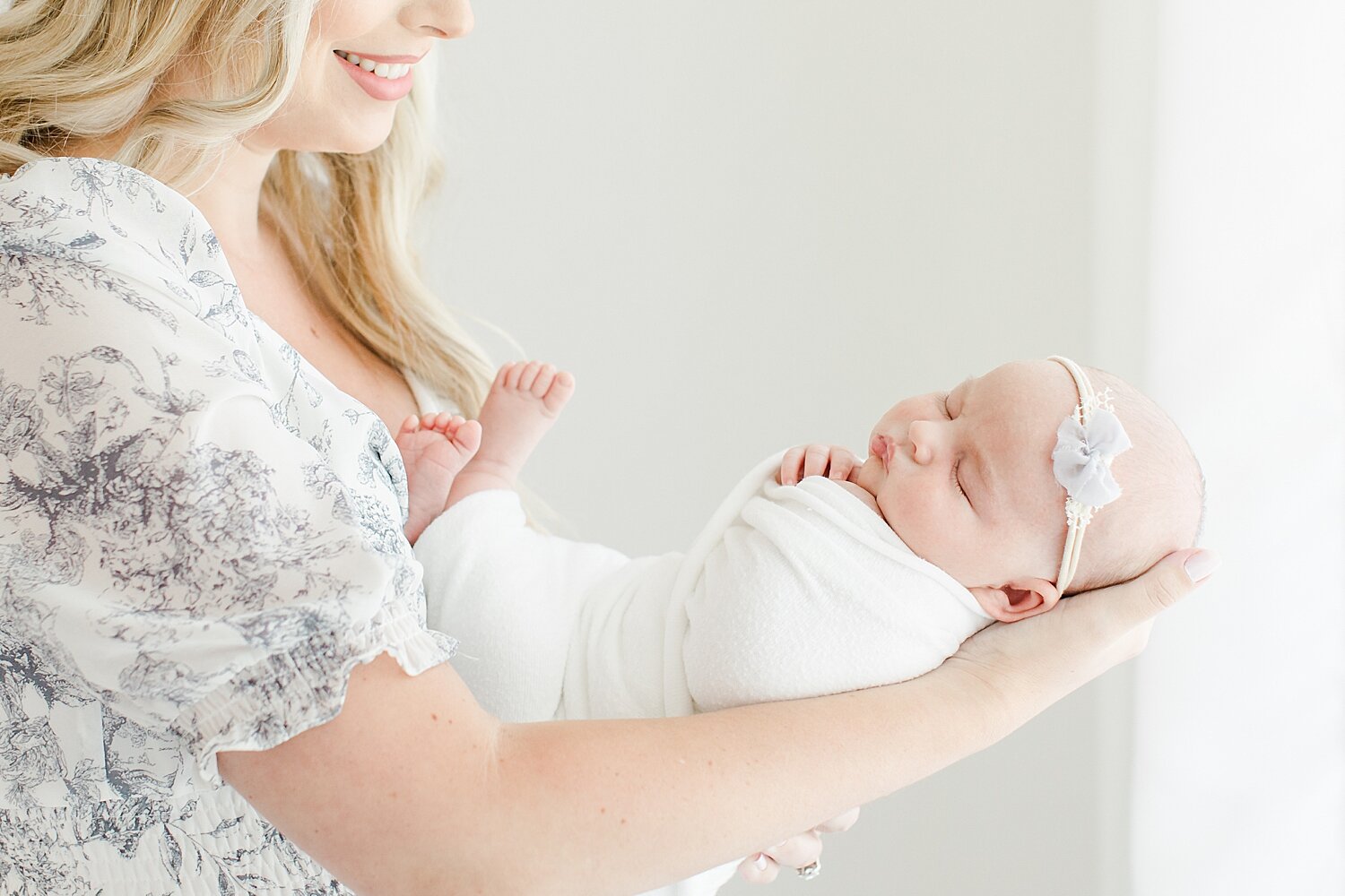 Mom holding her baby girl during newborn session in studio in Fairfield County, CT. Photos by Kristin Wood Photography.