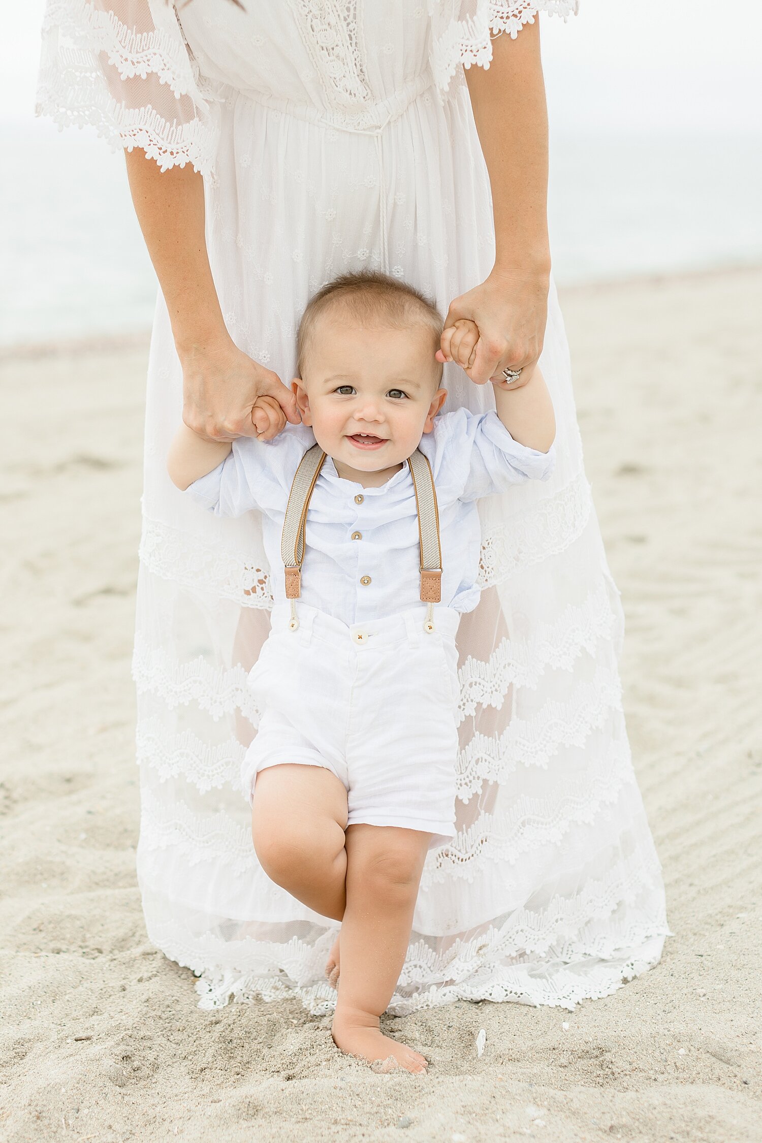 One year old on the beach in suspender shorts | Kristin Wood Photography