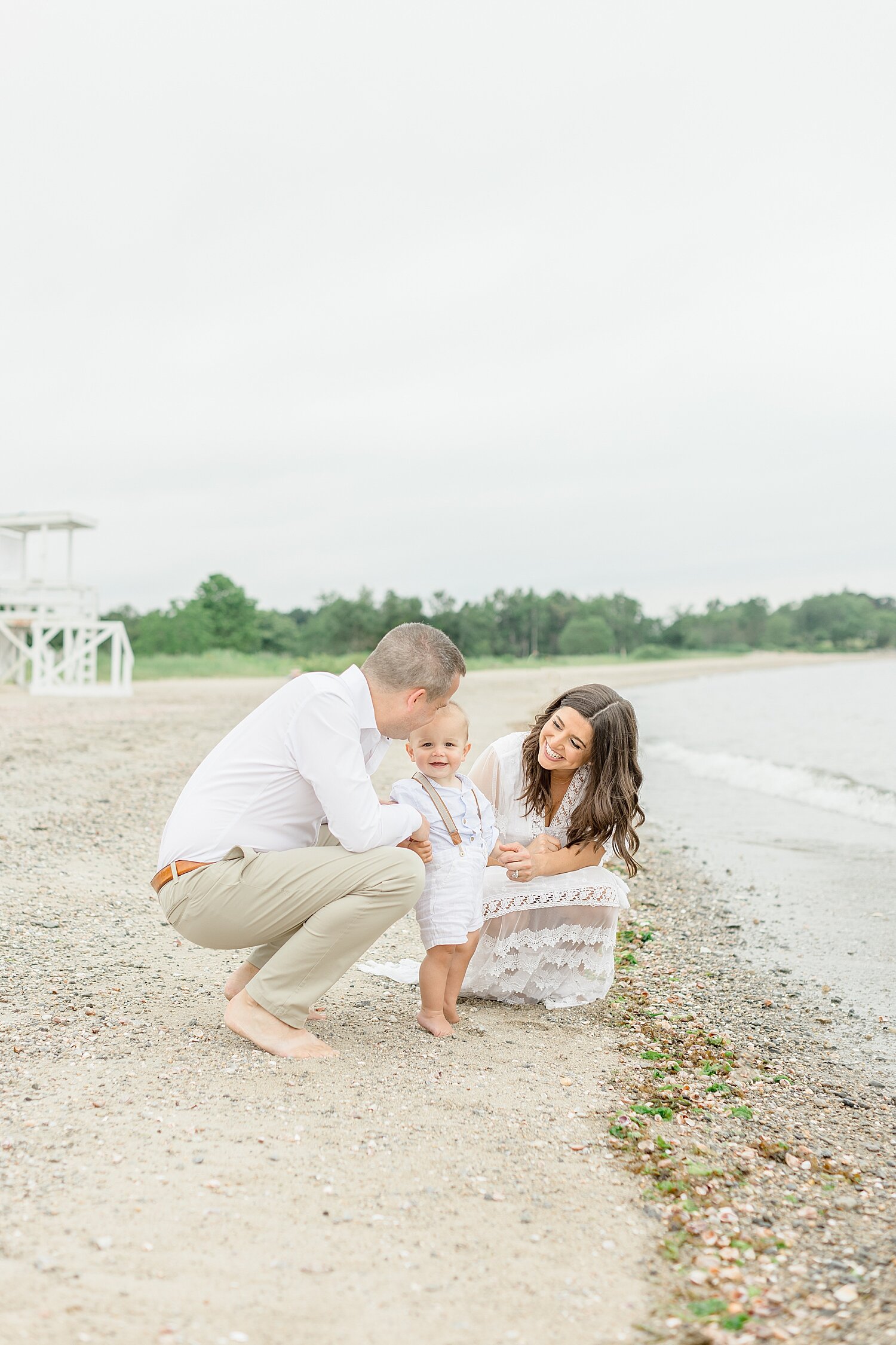 Family sitting along the water for photos with son | Kristin Wood Photography