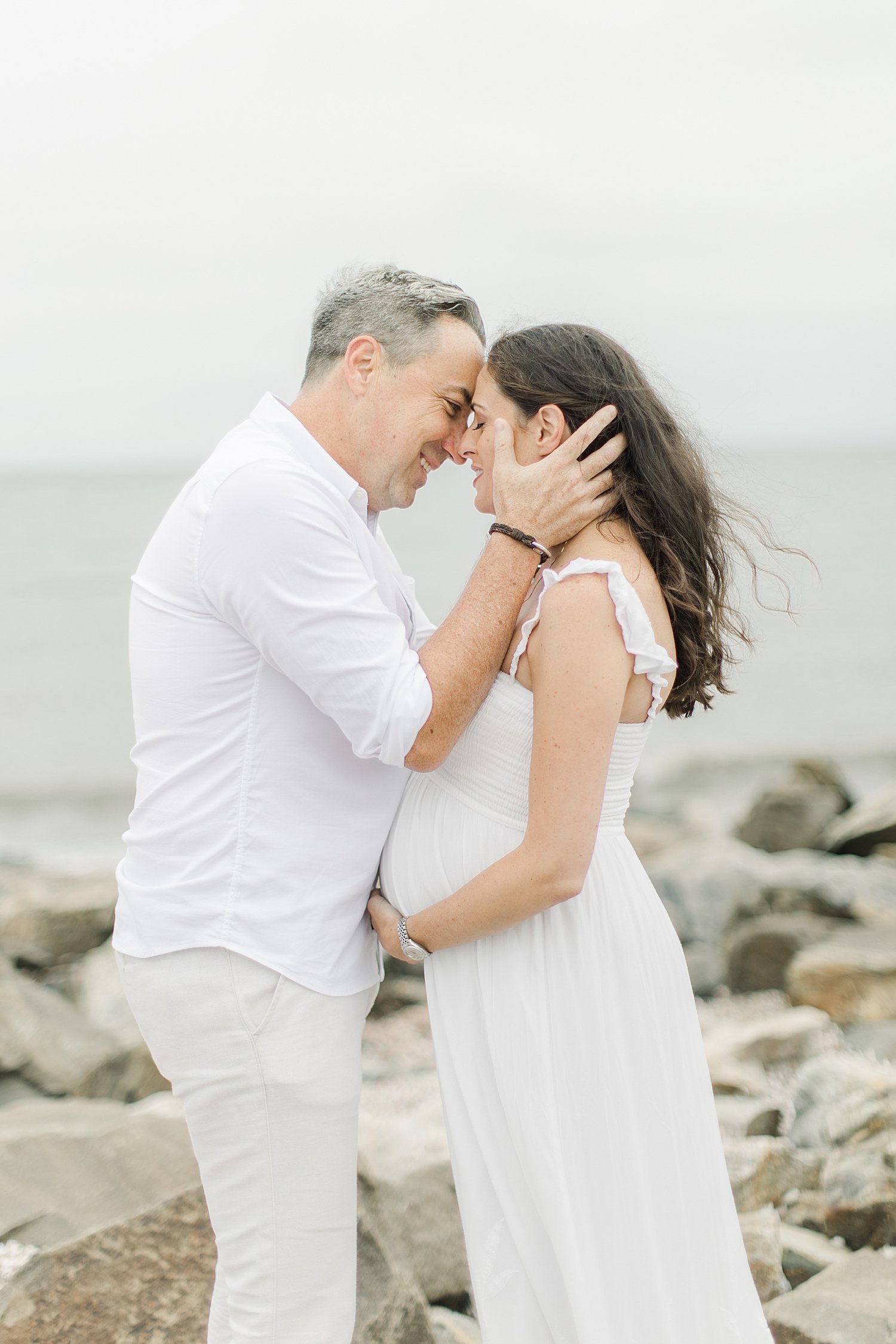 Expecting parents sharing a special moment at Sherwood Island during maternity session with Kristin Wood Photography.