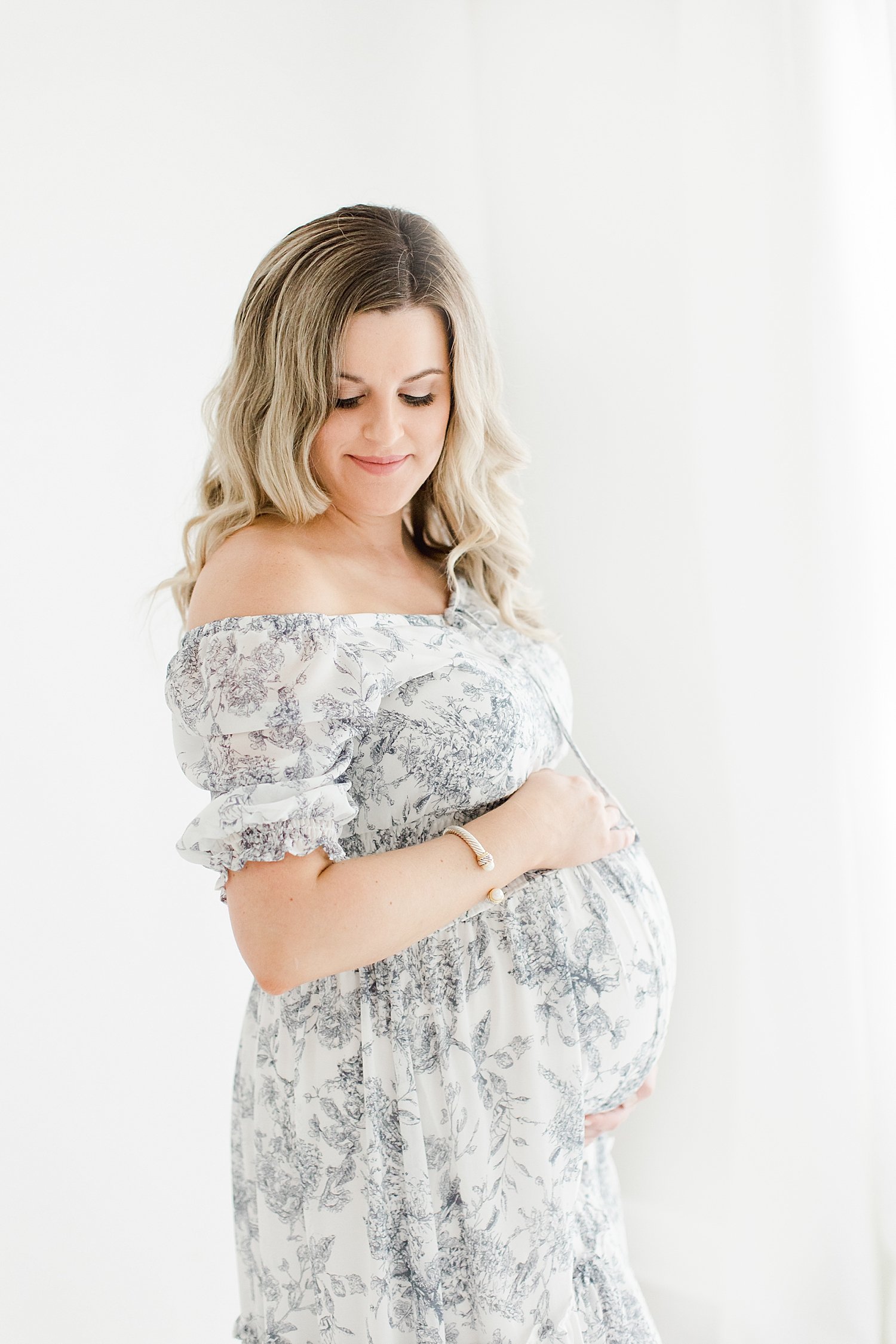 Mom-to-be wearing floral dress for studio maternity session with Kristin Wood Photography.