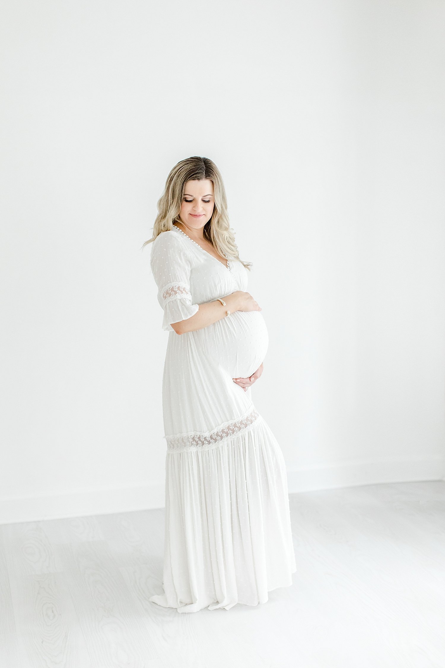 Pregnant mom wearing a white dress for studio maternity session | Kristin Wood Photography