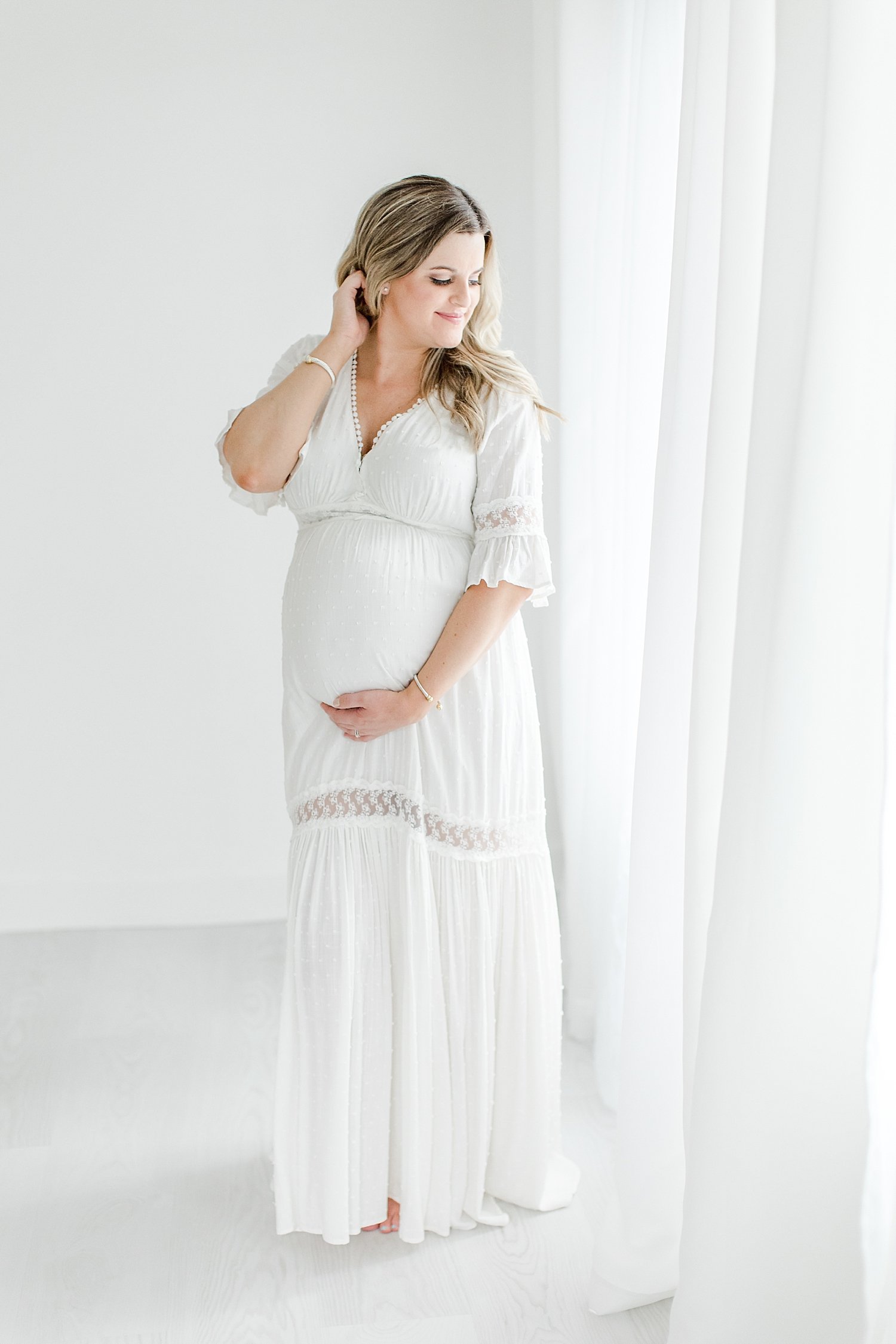 Pregnant mom wearing a white dress for studio maternity session | Kristin Wood Photography