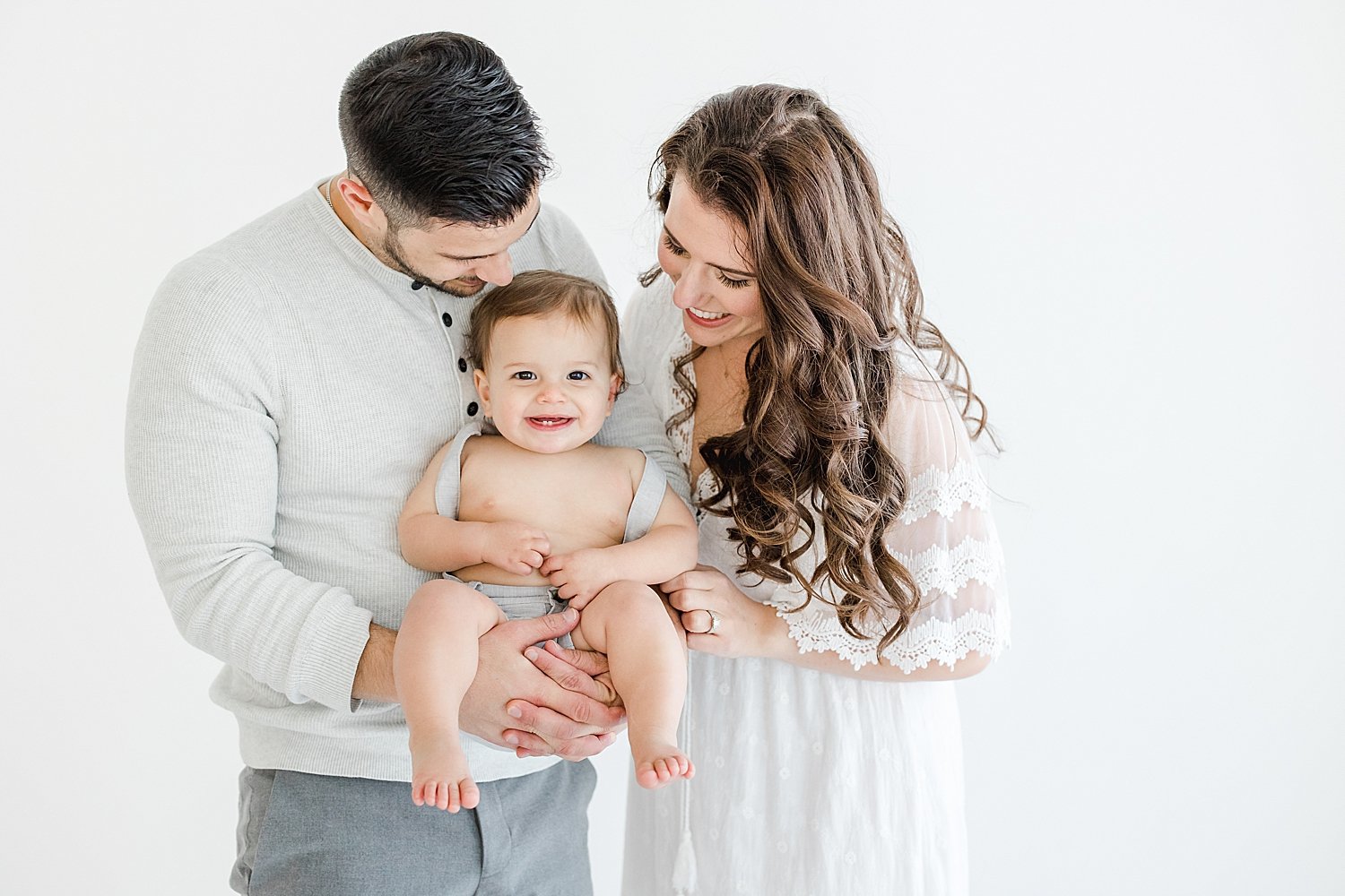 Why You Should Hire a Photographer for Your Baby's First Year | Mom and Dad playing with one year old son during birthday session with Kristin Wood Photography
