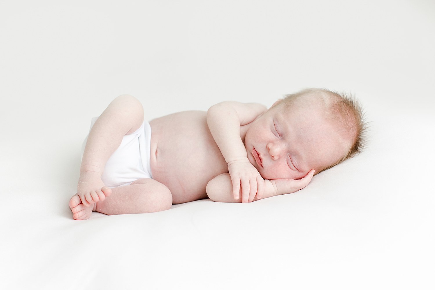 Newborn baby boy laying on his side for photos | Kristin Wood Photography