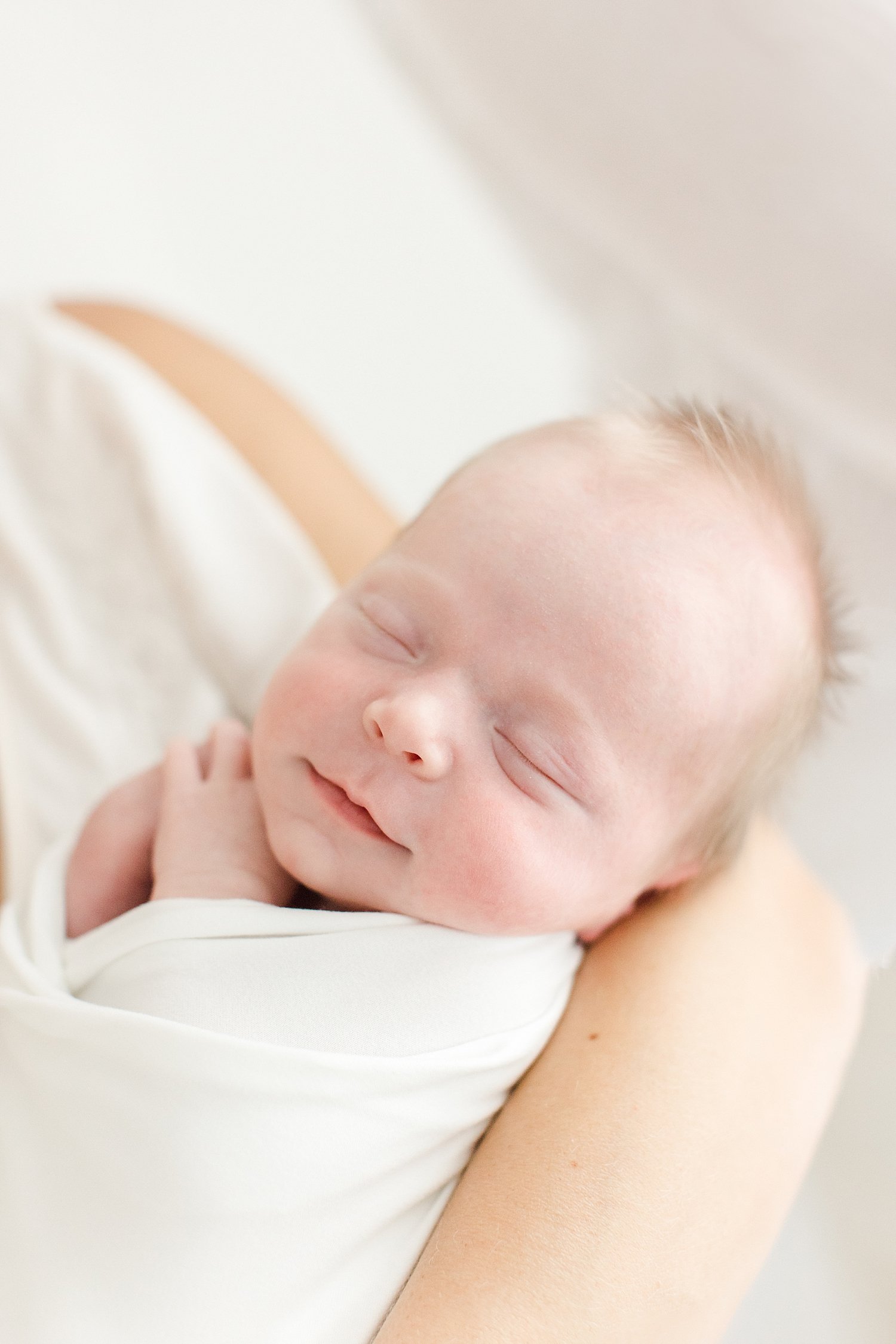 Up-close photo of newborn baby boy in his moms arms | Kristin Wood Photography