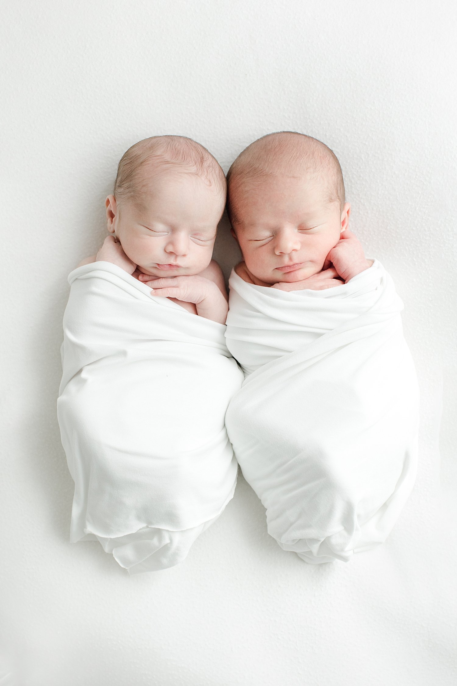 Twin boys swaddled for newborn photos with Kristin Wood Photography.