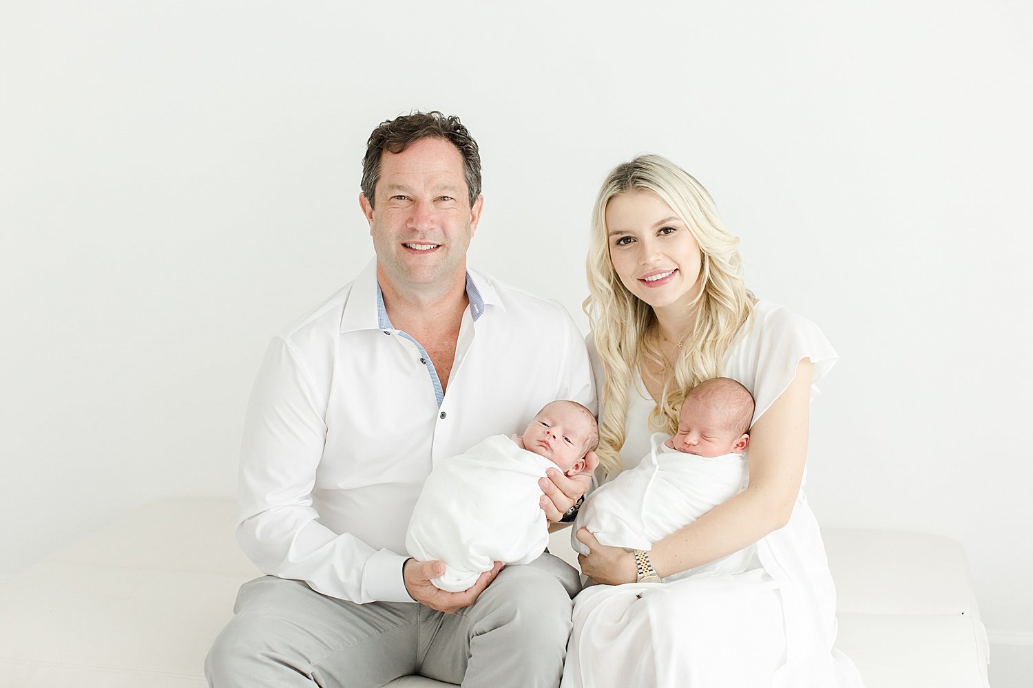 Mom and Dad holding their twin boys at newborn session with Kristin Wood Photography.