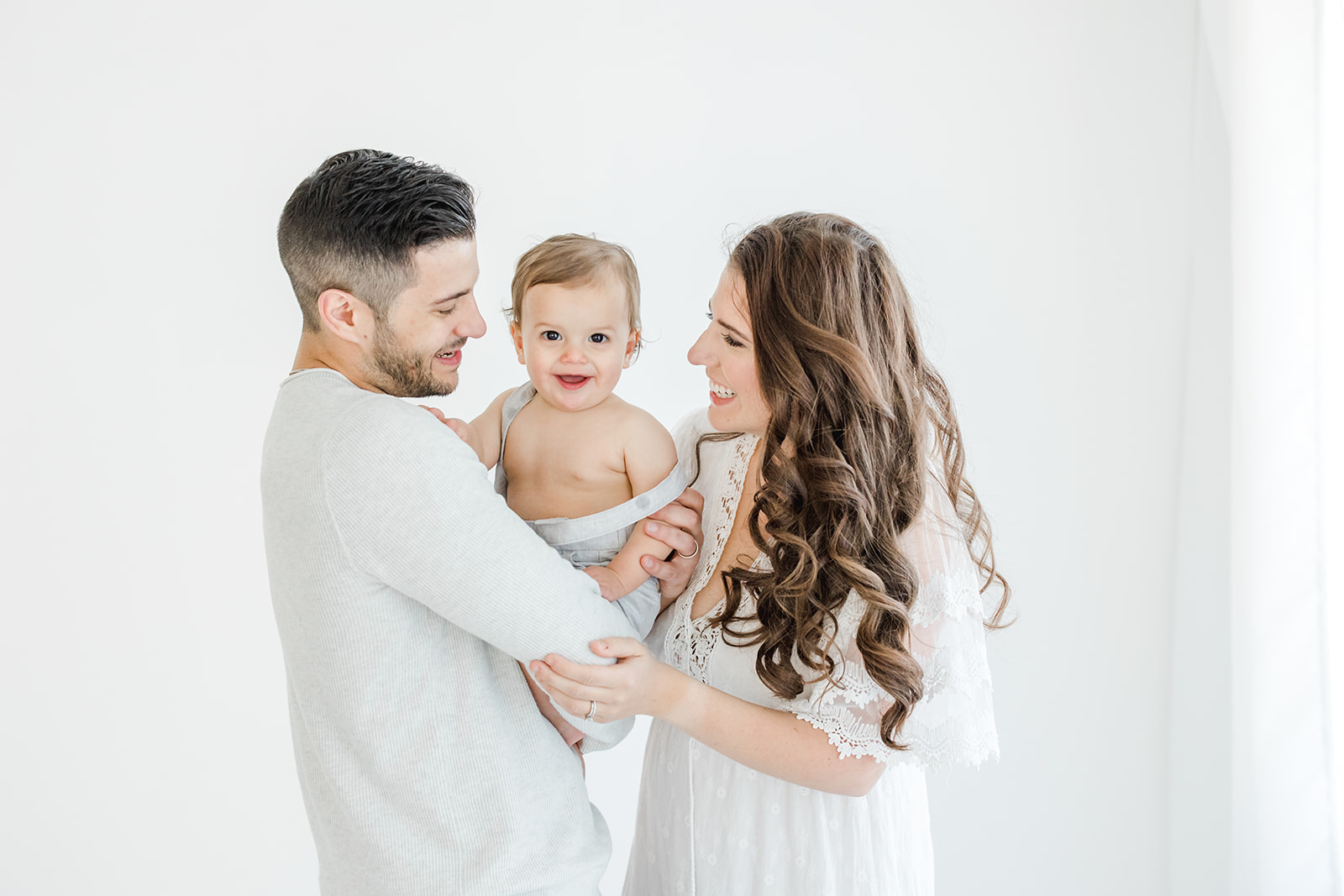 Why you should hire a photographer for your baby's first year | Mom and Dad holding their one year old son | Kristin Wood Photography