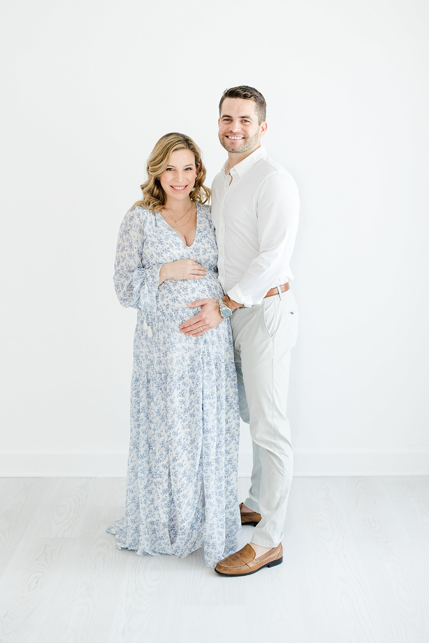 Expecting parents standing together for maternity photos with Kristin Wood Photography.