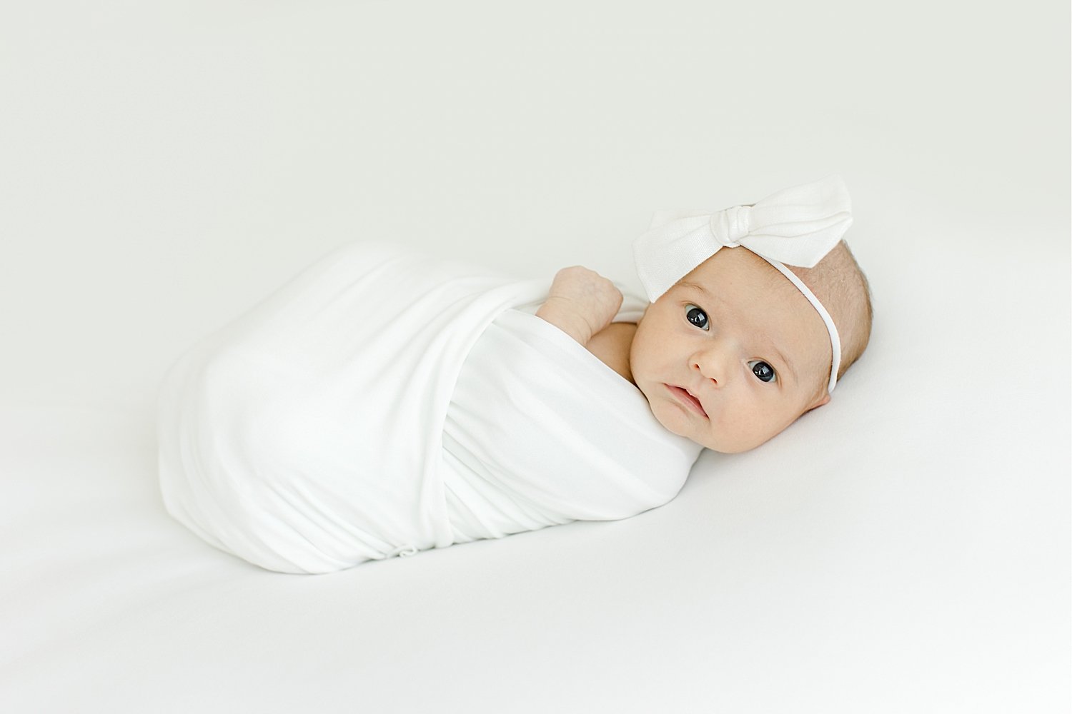 Baby girl swaddled with white headband | Kristin Wood Photography