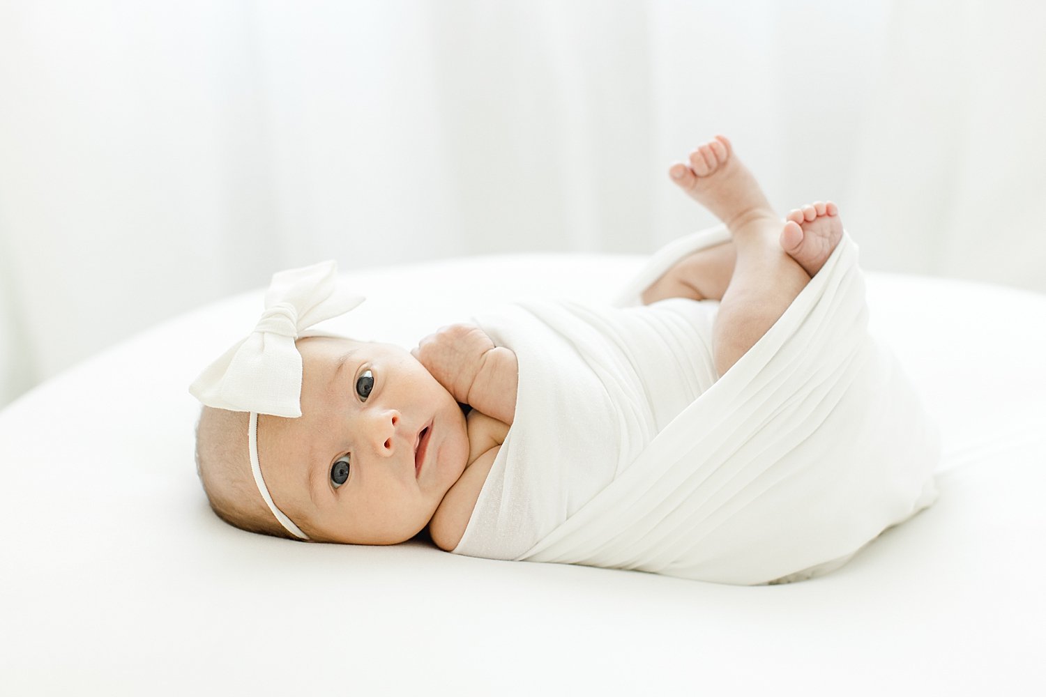 Baby girl swaddled with white headband | Kristin Wood Photography