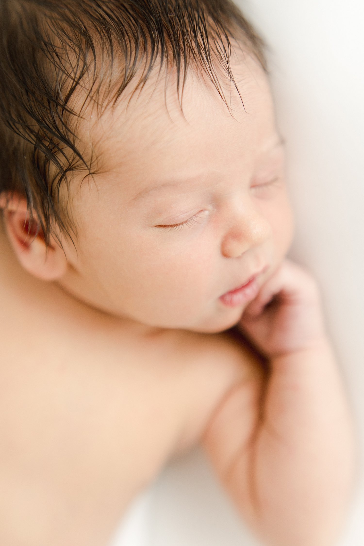 Baby boy with dark brown hair sleeping during newborn session | Kristin Wood Photography