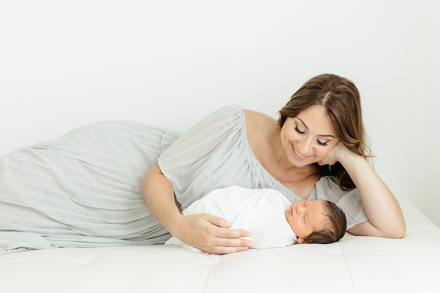 Mom laying with newborn son during photoshoot with Kristin Wood Photography.