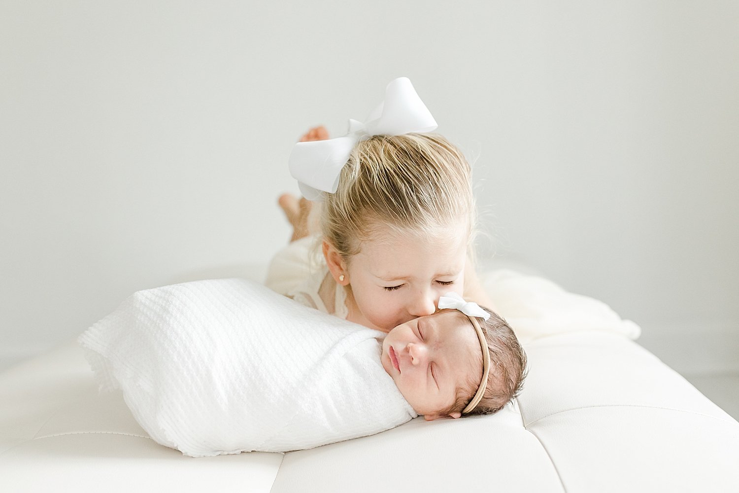 Big sister giving baby sister a kiss | Kristin Wood Photography