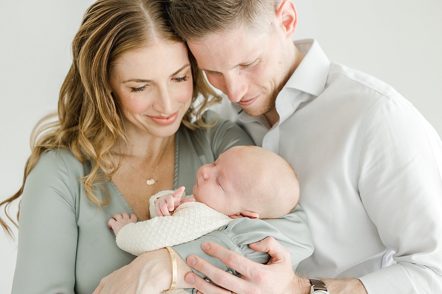 Mom and Dad holding their newborn son for photoshoot with Kristin Wood Photography.